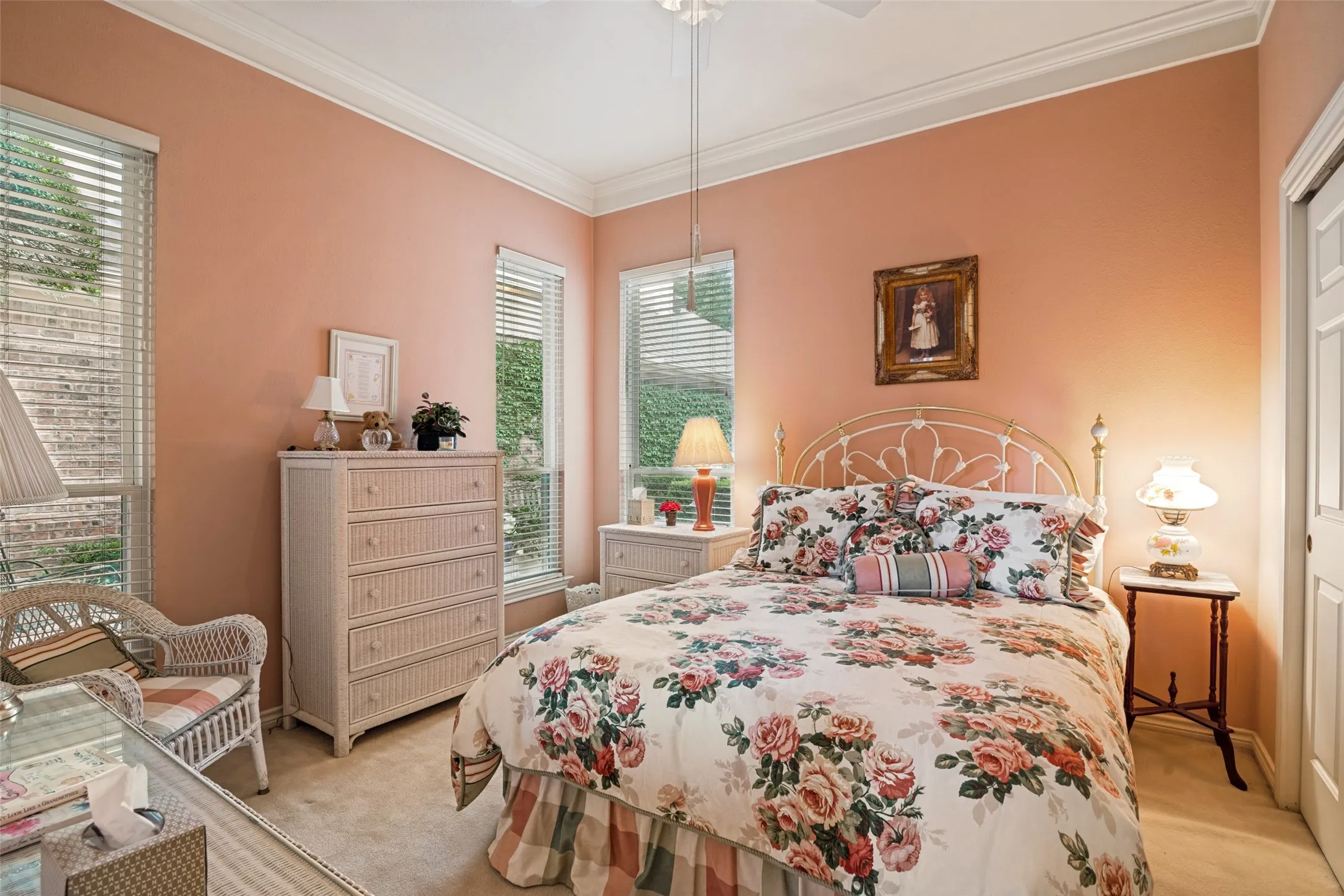 Carpeted room with a ceiling fan, crown molding, and multiple windows with blinds