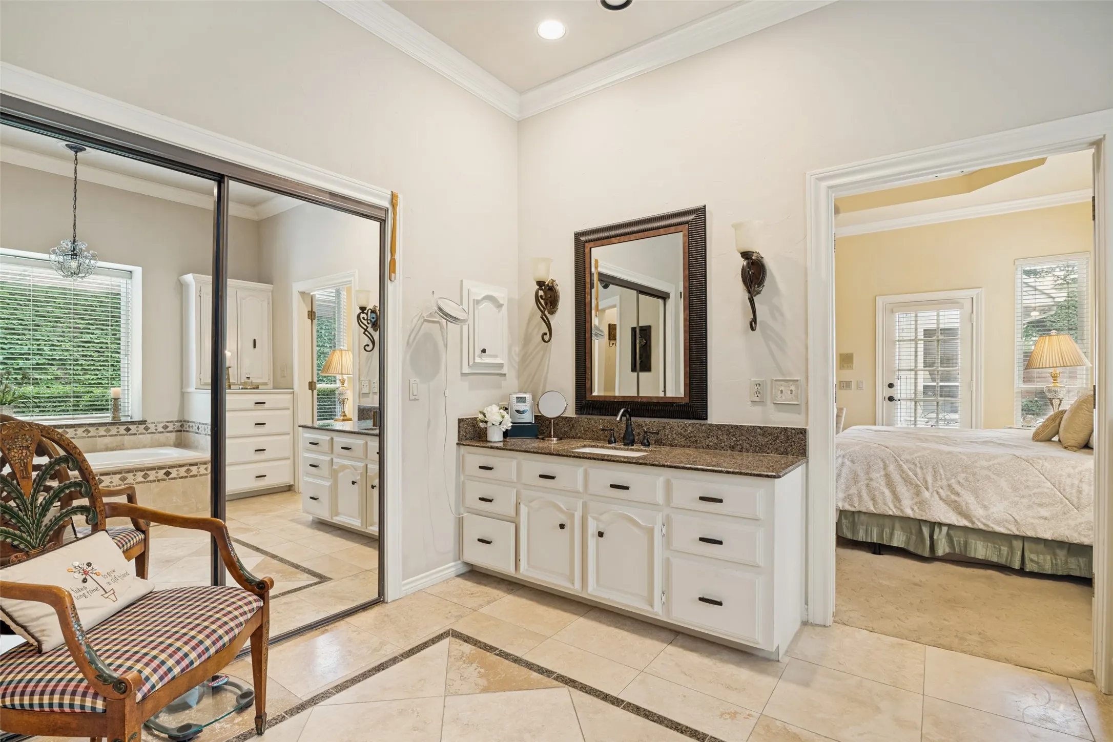 Bathroom vanity featuring a granite countertop, undermount sink, and white cabinetry with dark hardware