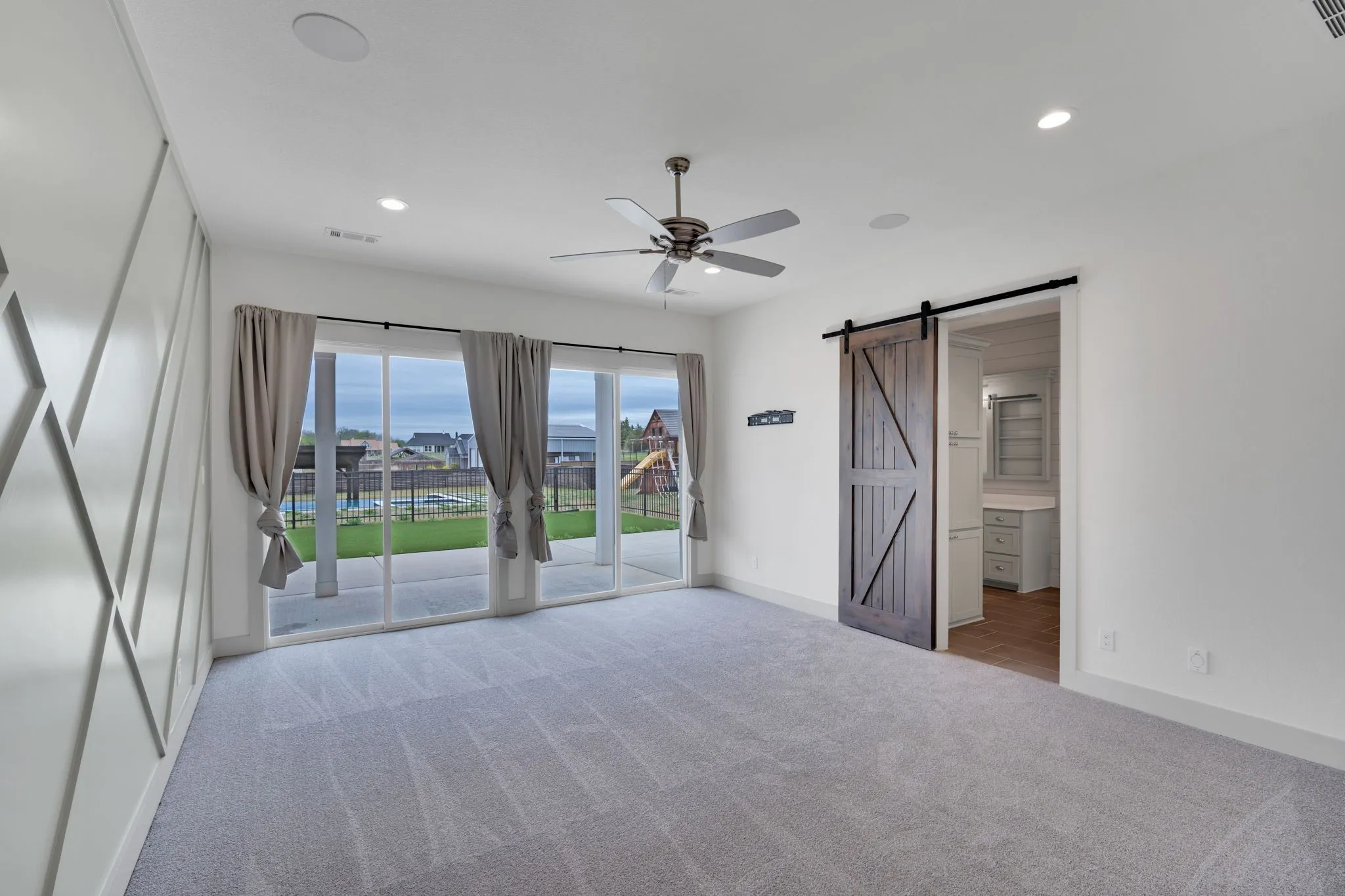 Primary bedroom overlooks pool and backyard