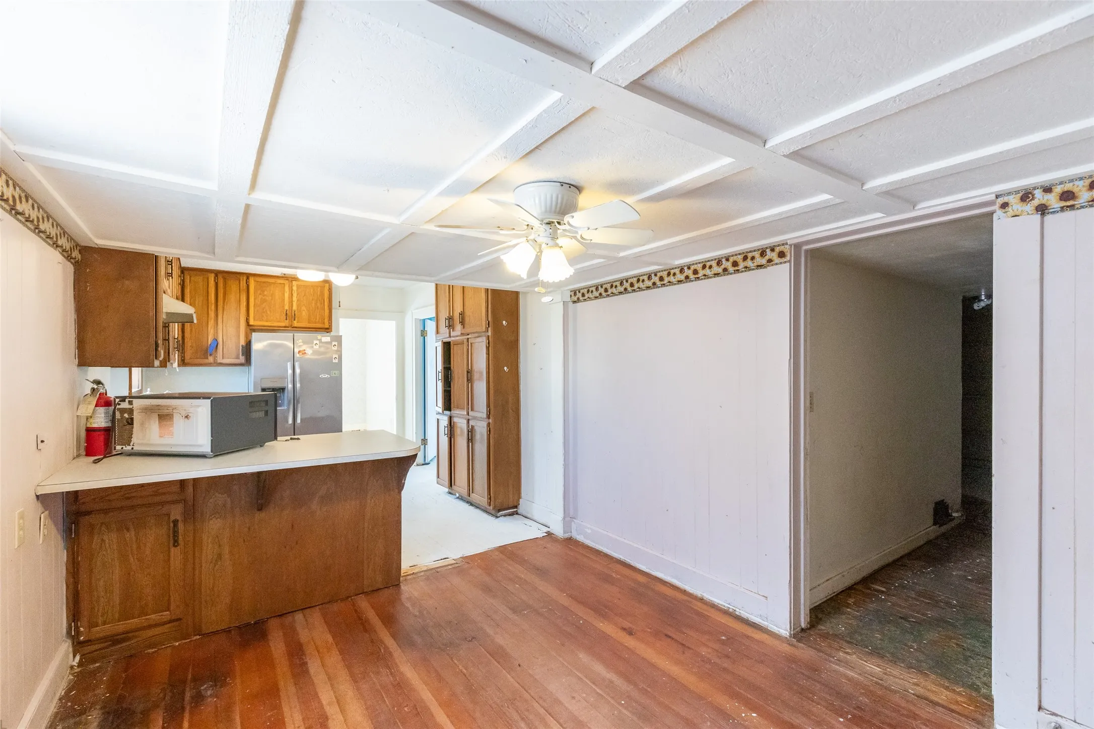 Kitchen area featuring wood-finish flooring and a coffered ceiling