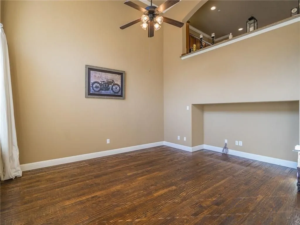 Expansive room featuring high ceilings and wood-finish flooring