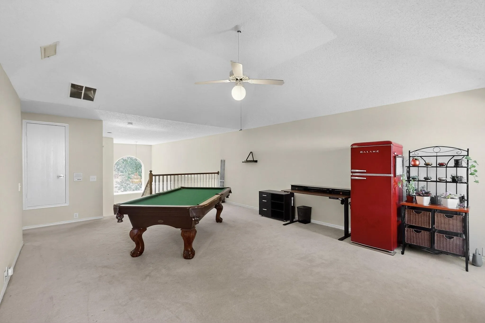 Spacious bonus room featuring a vaulted ceiling, ceiling fan, and carpeted flooring