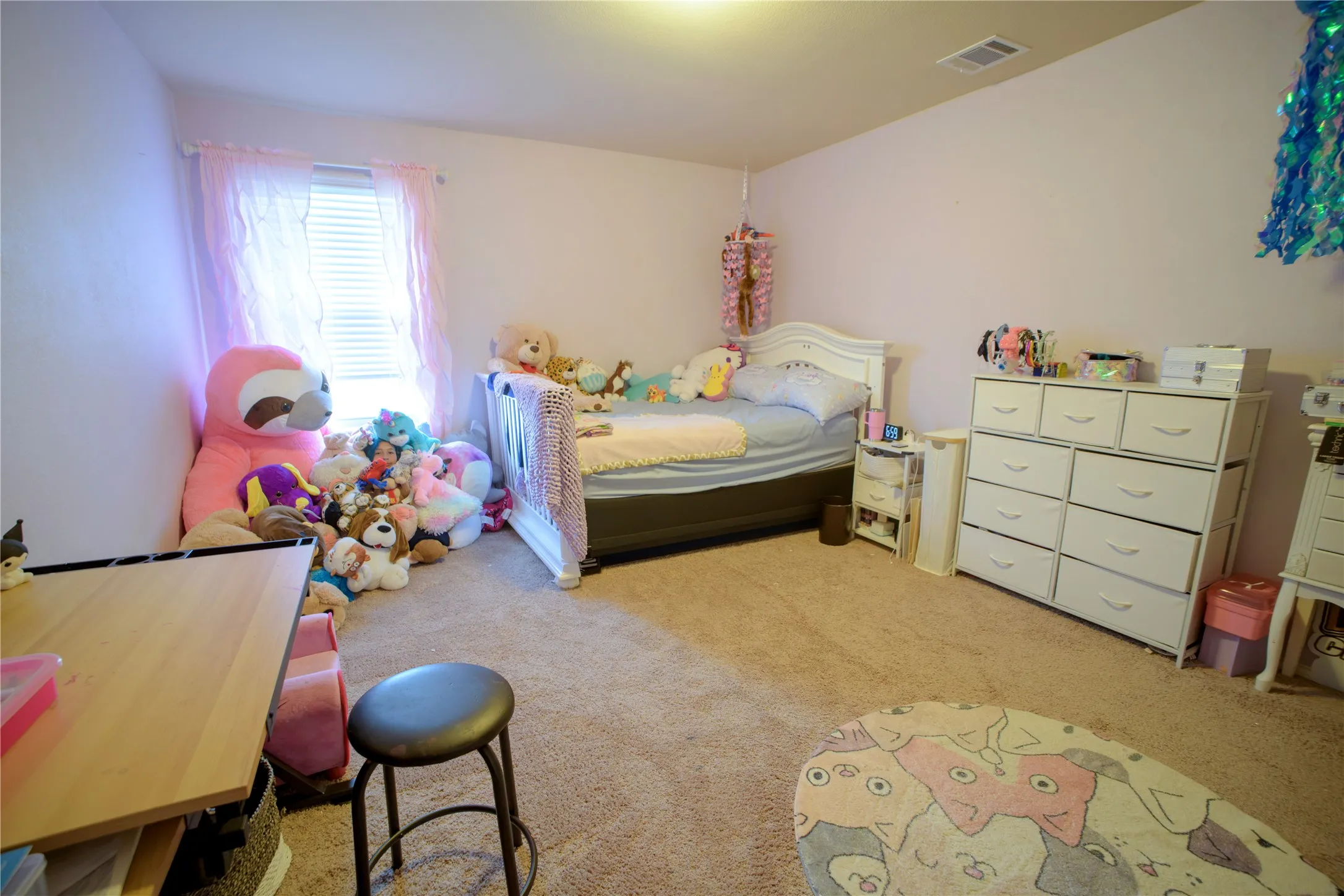 Carpeted room featuring a window with blinds, a ceiling light fixture, and light-toned walls