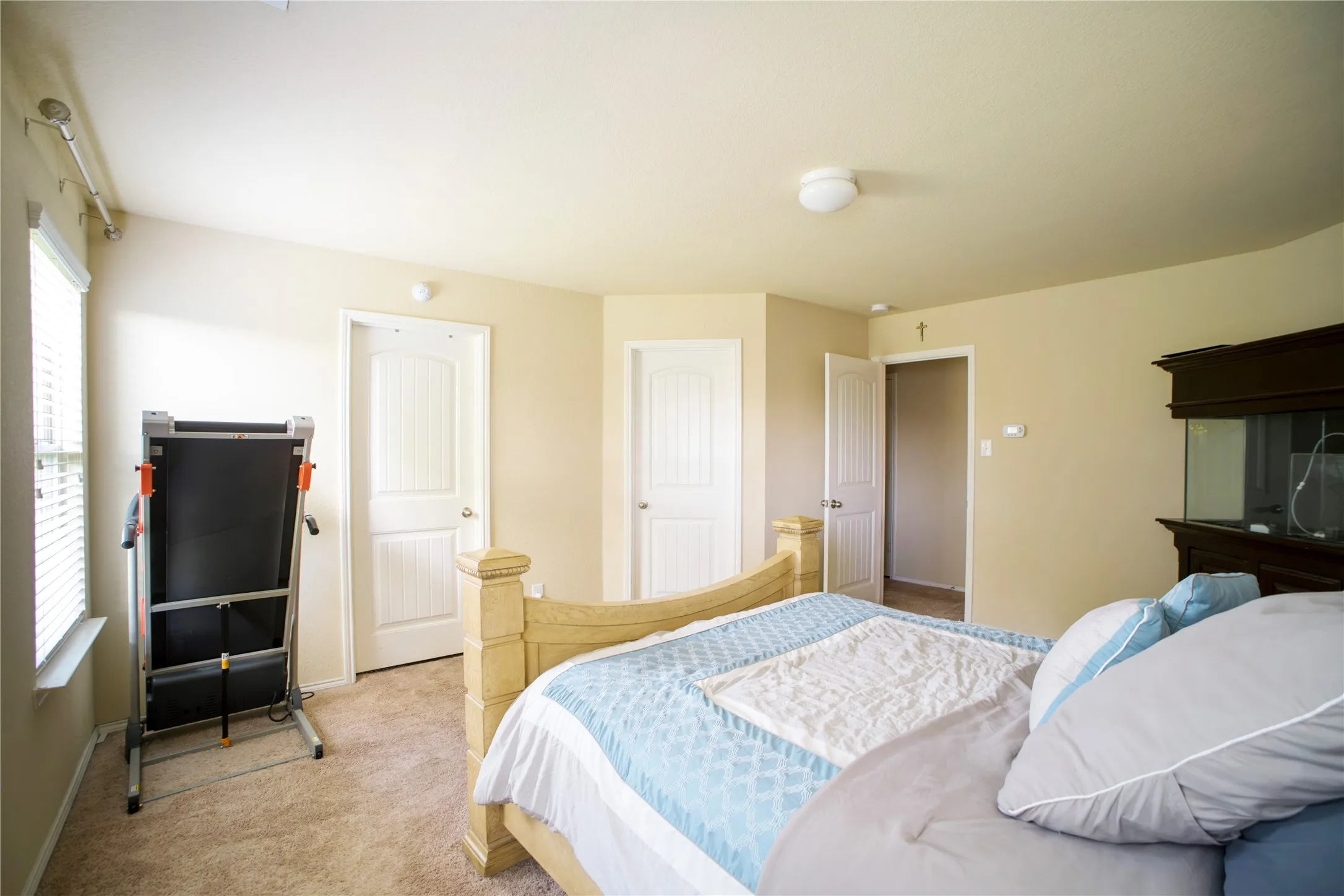 Carpeted room with multiple interior doors, a window with horizontal blinds, and a flush mount ceiling light
