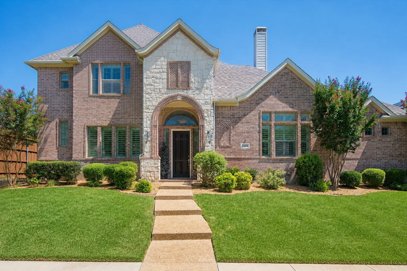 Front exterior image digitally enhanced using AI to improve visibility of the home's front elevation by removing tree branches.