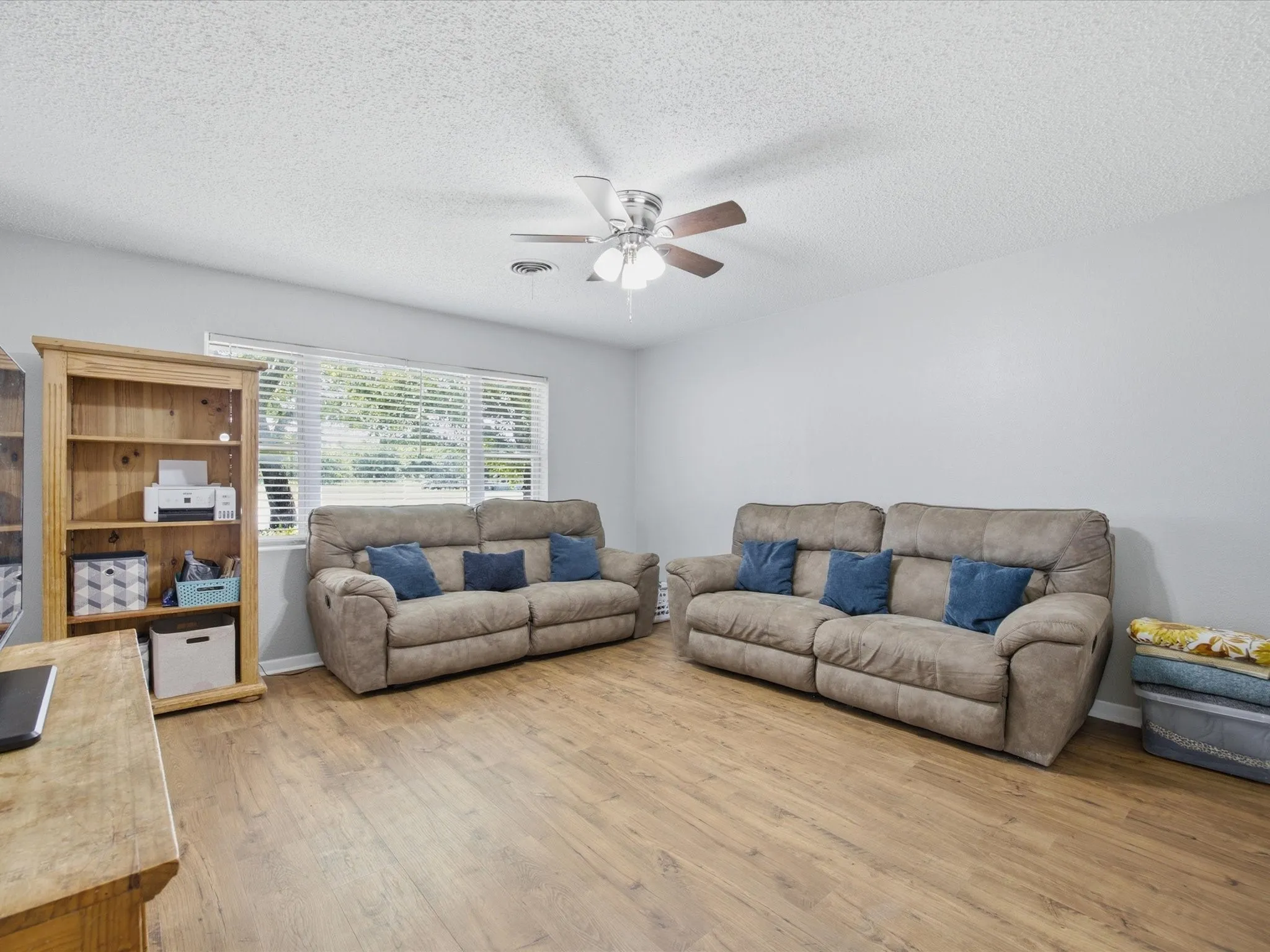 Living Room with natural Light, Ceiling Fan, and vinyl plank flooring