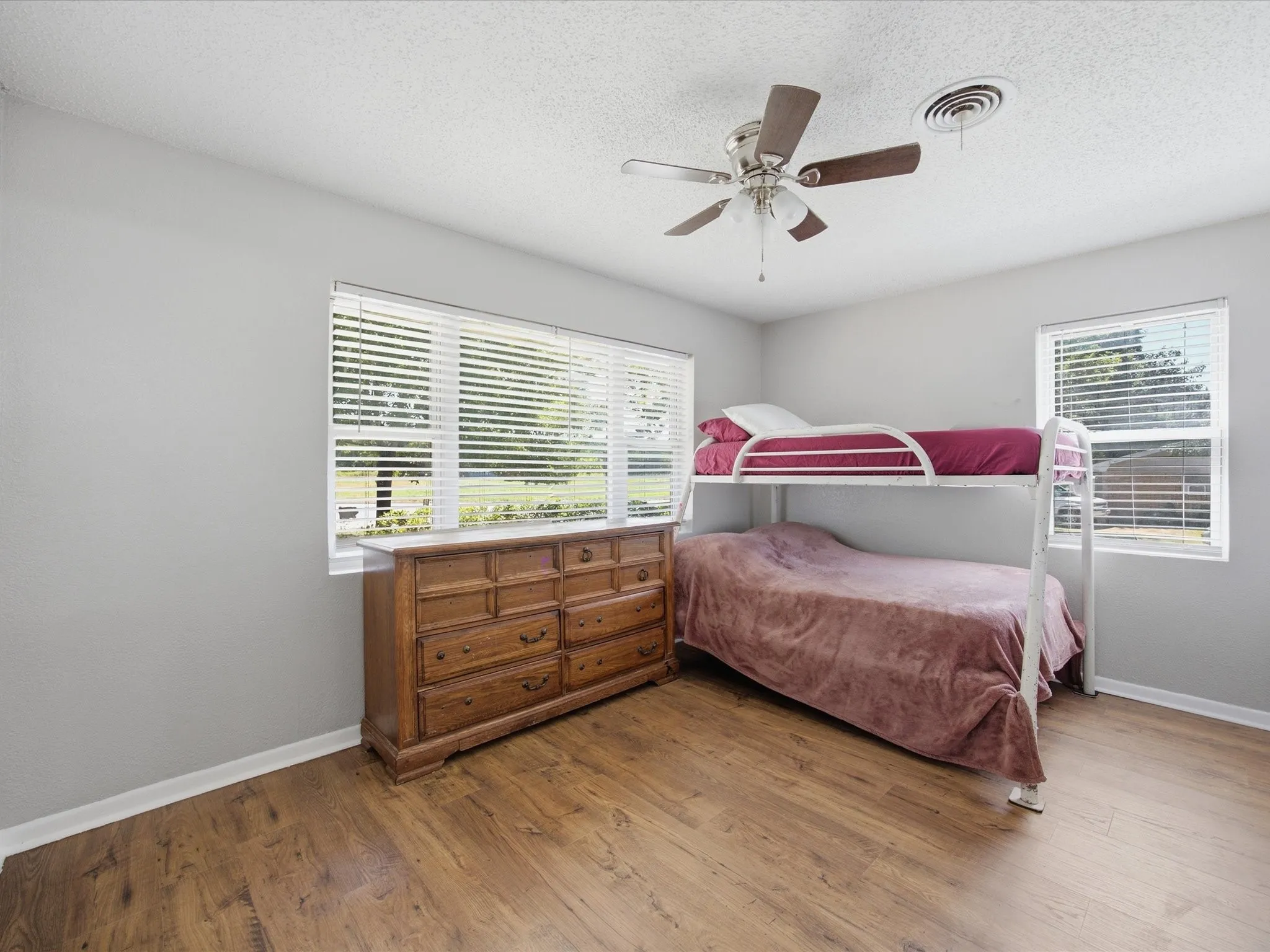 Bedroom number 2 with an Abundance of natural light, Ceiling Fan, vinyl plank flooring, and Baseboards