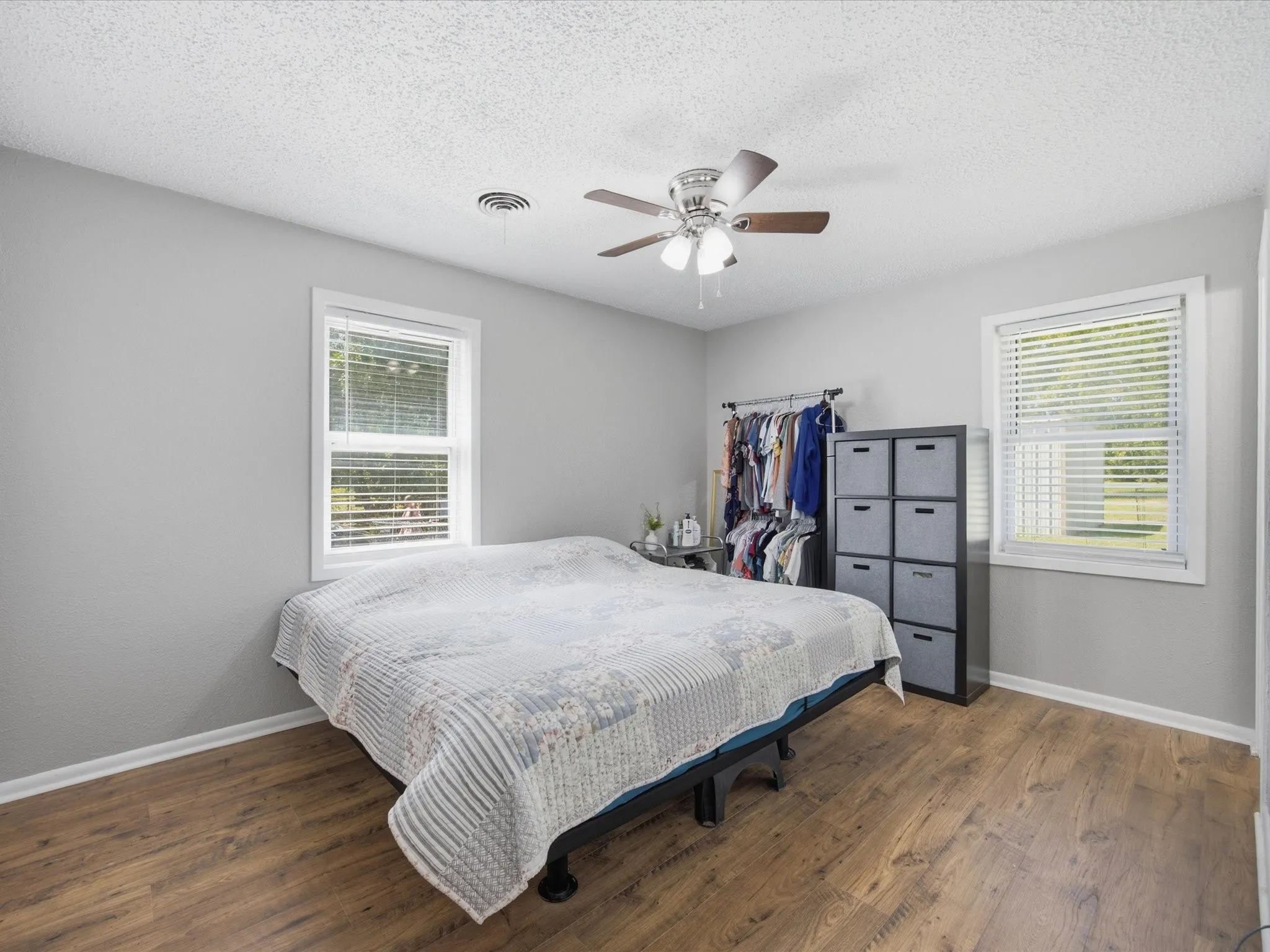 Primary Bedroom with light gray walls,  vinyl plank flooring, and Ceiling Fan