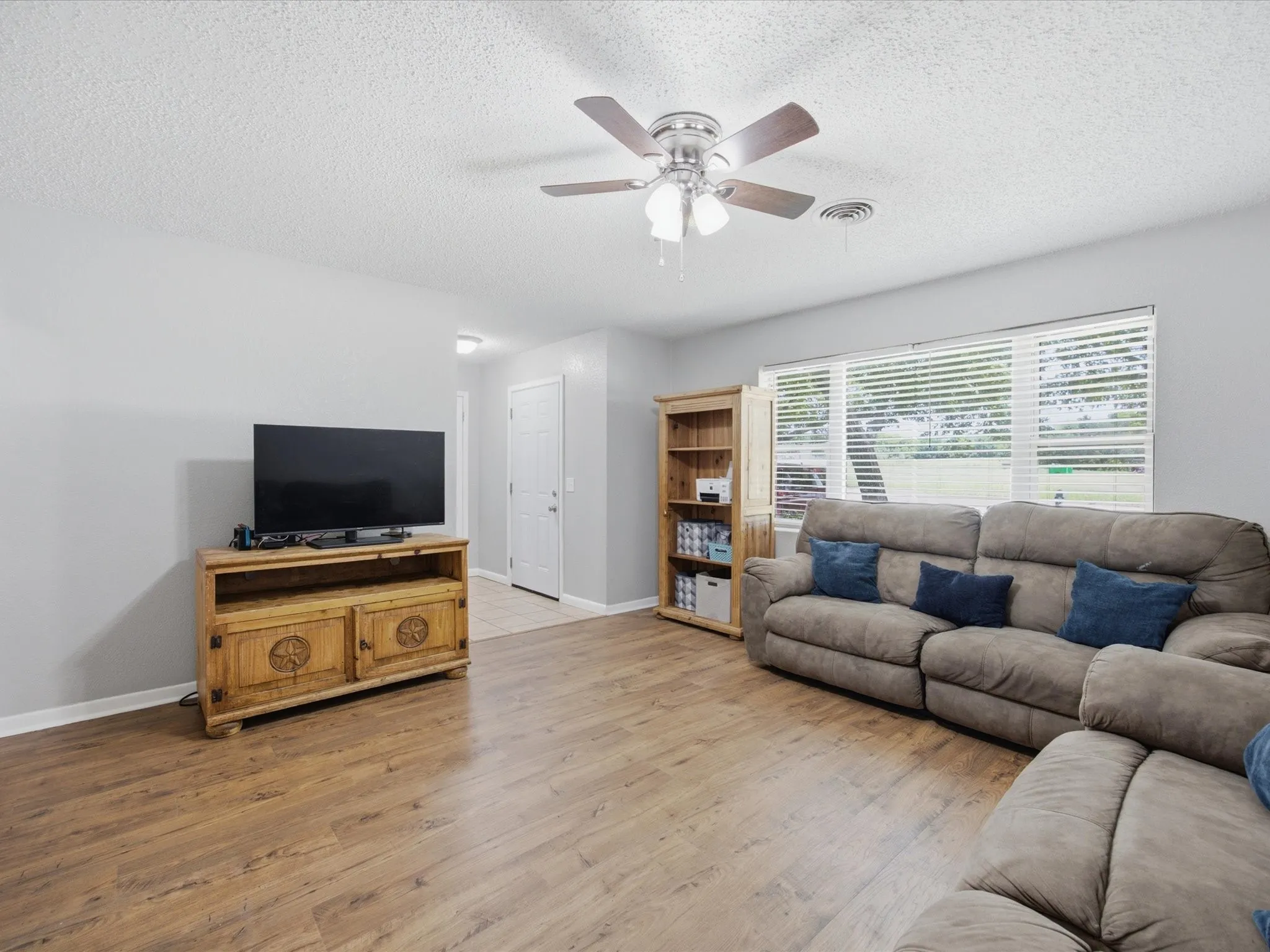 Spacious Living Room with Lots of natural Light, and vinyl plank flooring.