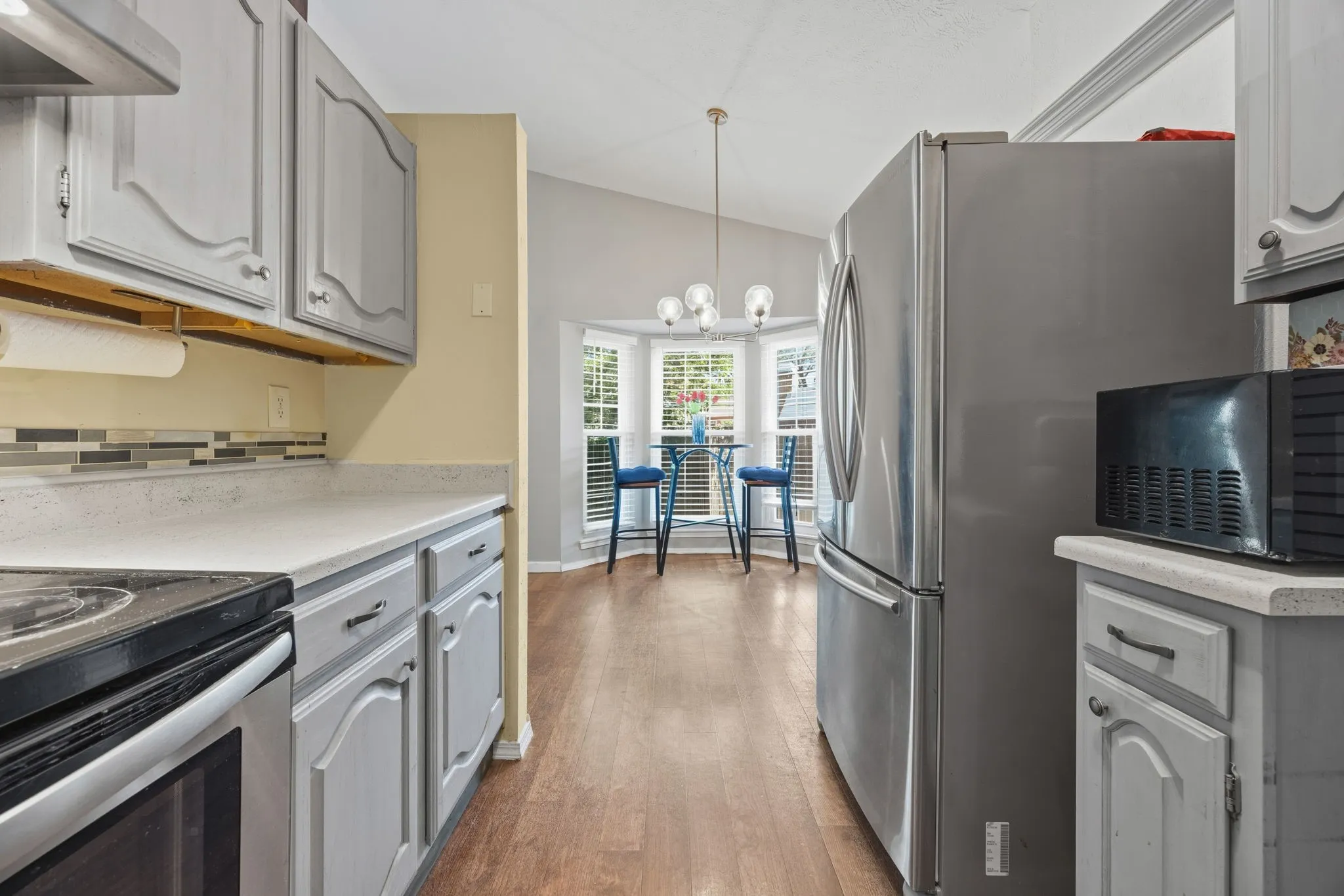 Open kitchen with stainless refrigerator leads directly into a
bay-window breakfast nook