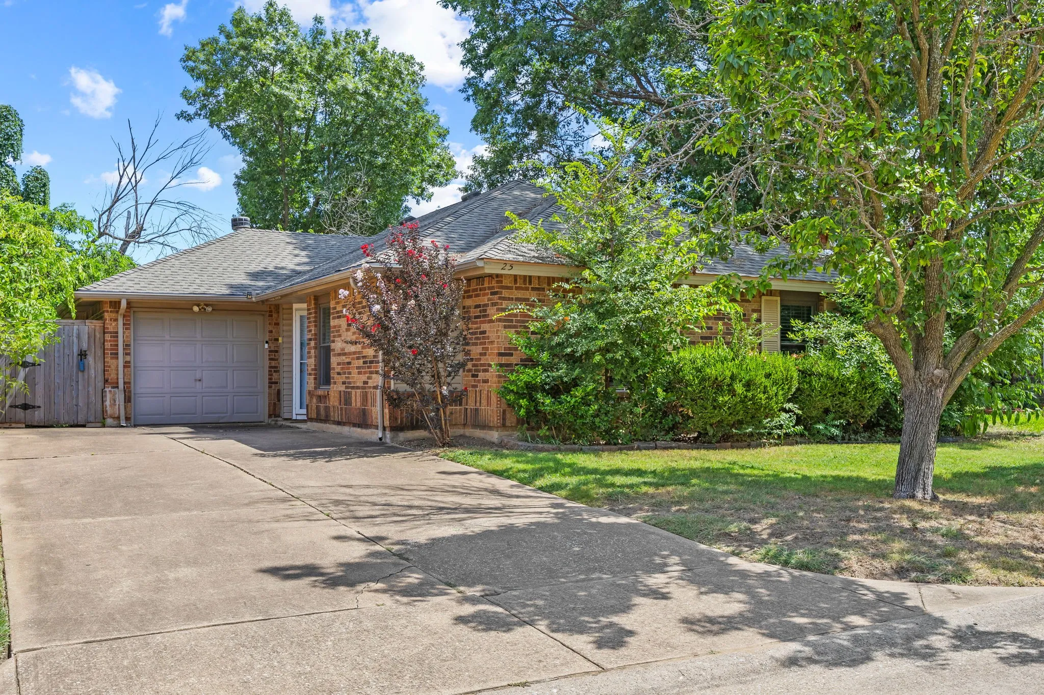 Front exterior of this Allen, TX home, showing brick
construction, a one-car garage, and mature landscaping