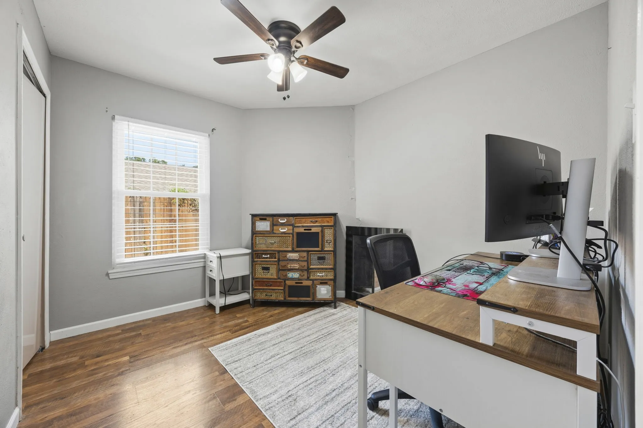 Third bedroom used as a home office, with LVP
floors and space for a dual-monitor desk setup.