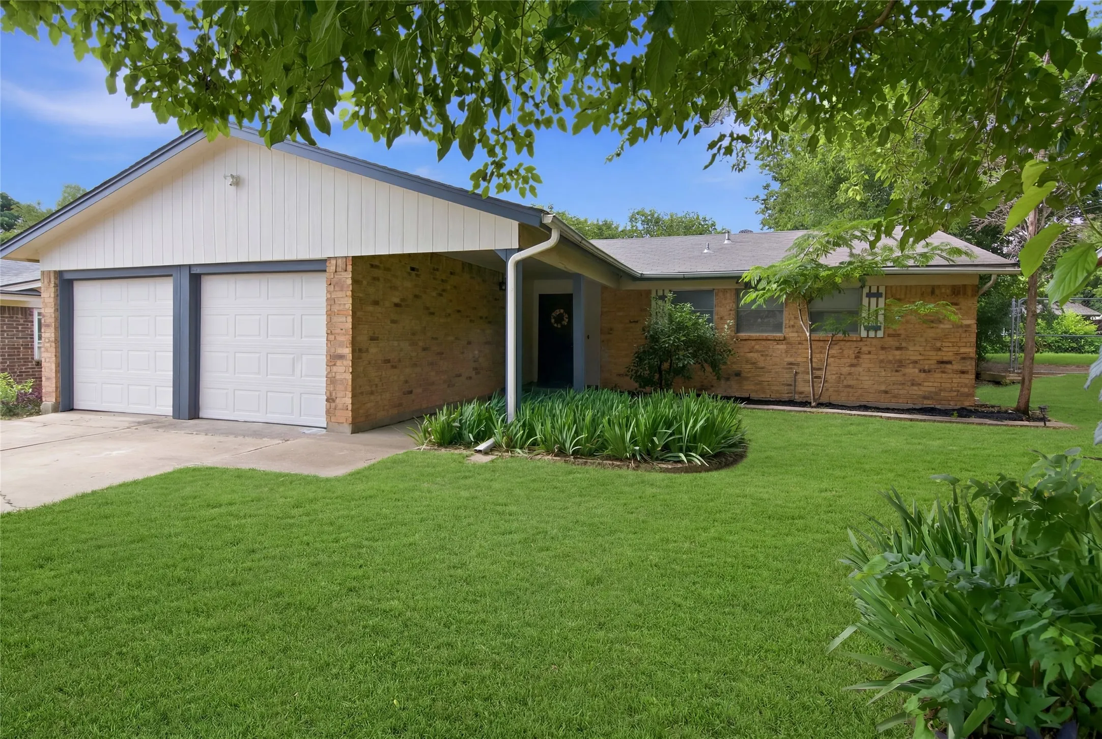 Ranch-style residence featuring a brick exterior and a two-car garage with panel doors
