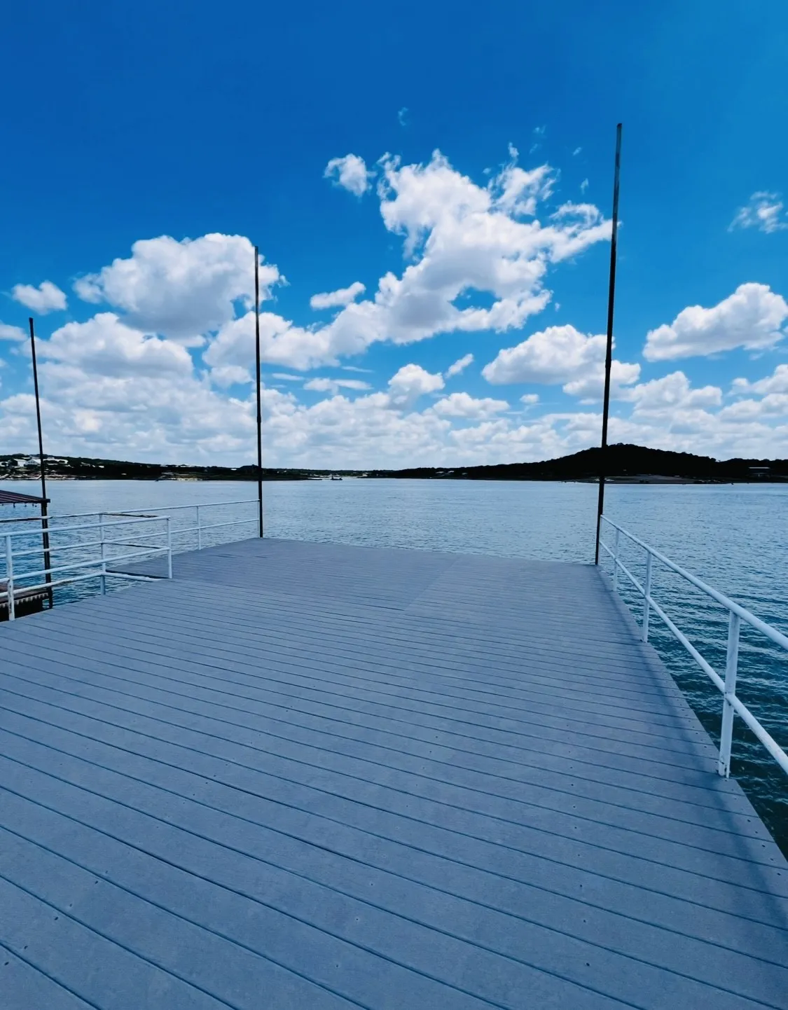 Spacious dock with composite decking and white metal railings providing direct water access