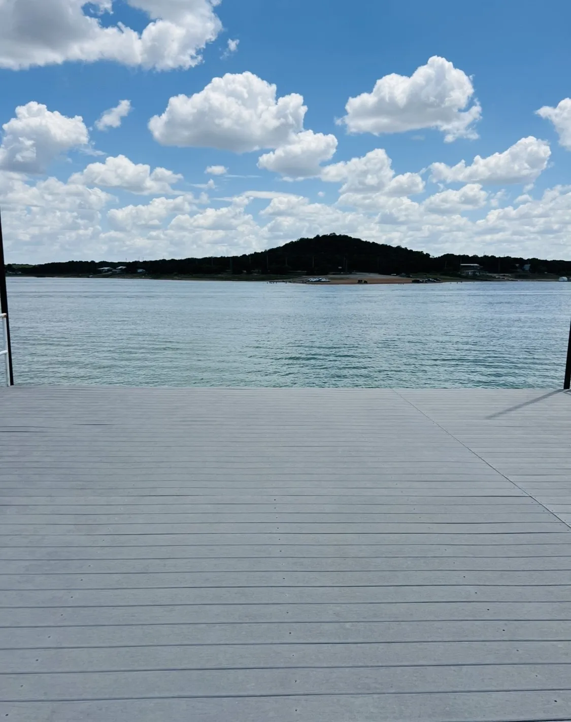 Waterfront setting featuring a spacious dock with grey composite decking