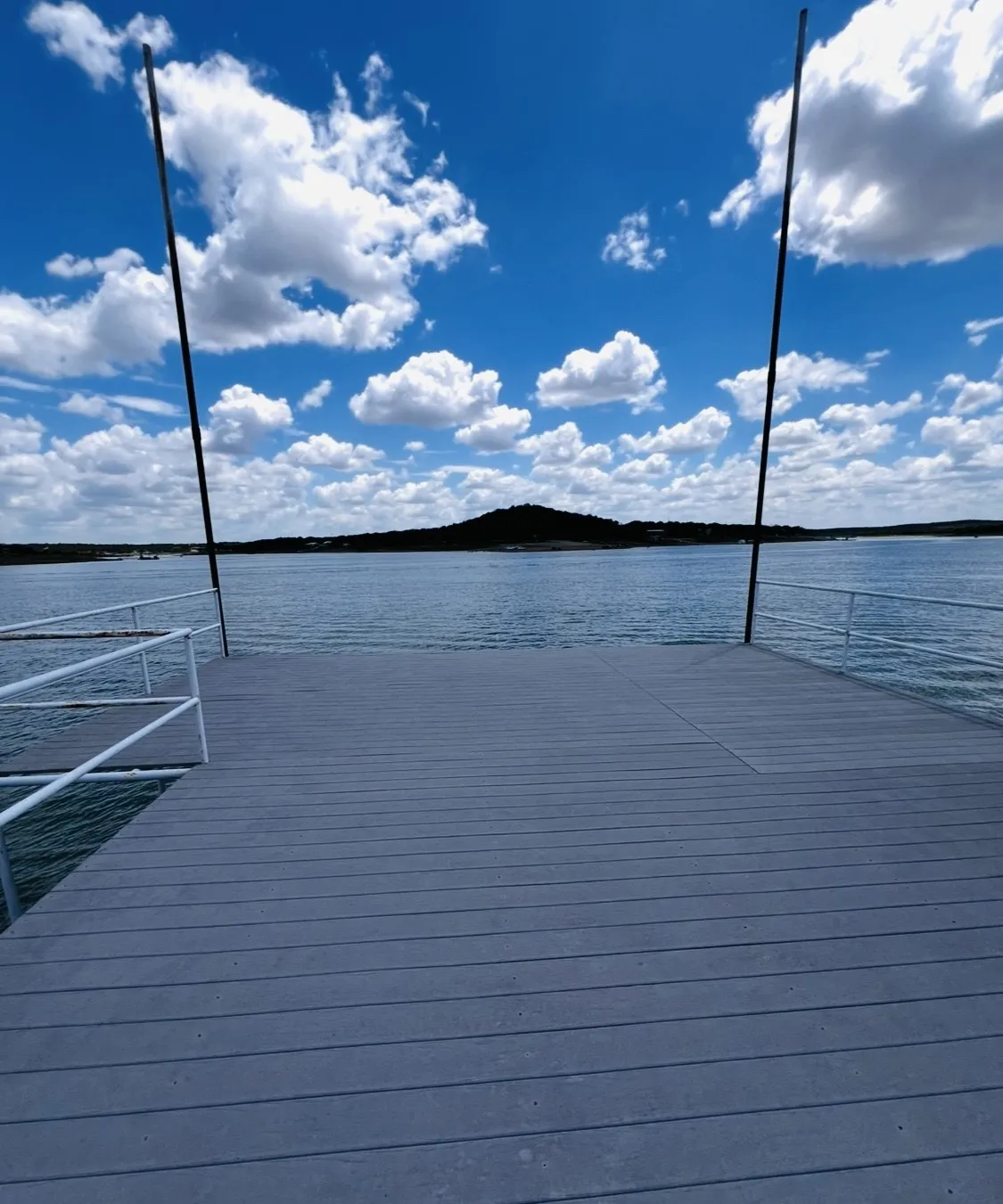 Dock with grey composite decking, white railings, and direct water access