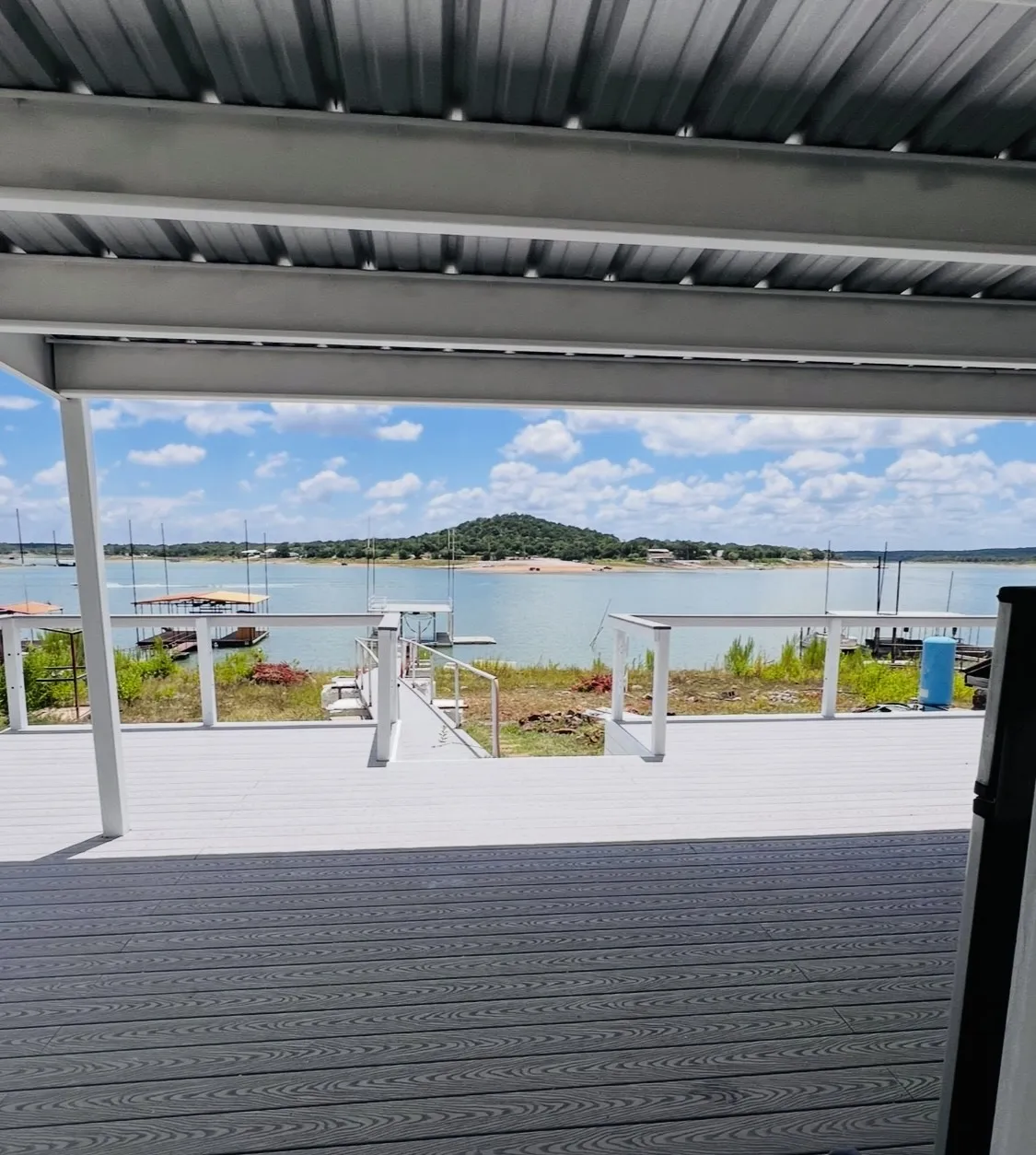 Expansive covered deck featuring composite decking in contrasting grey tones and a metal roof