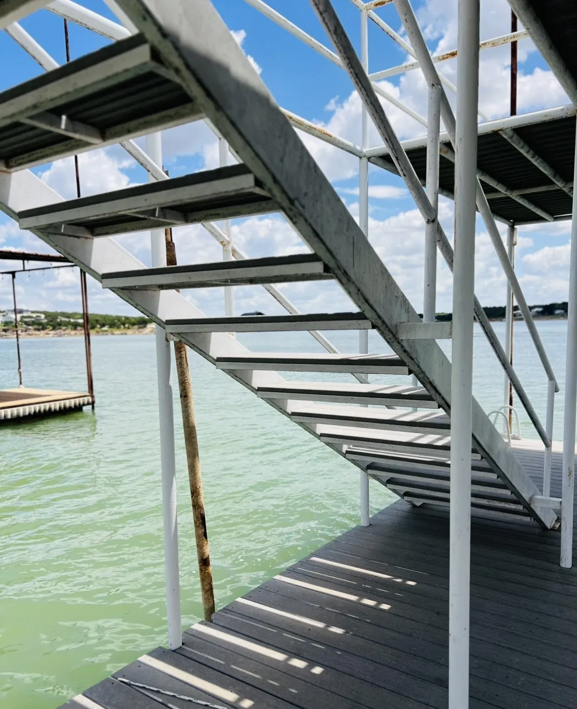 Metal stairway on a composite decking dock, featuring slip-resistant stair treads and robust structural supports