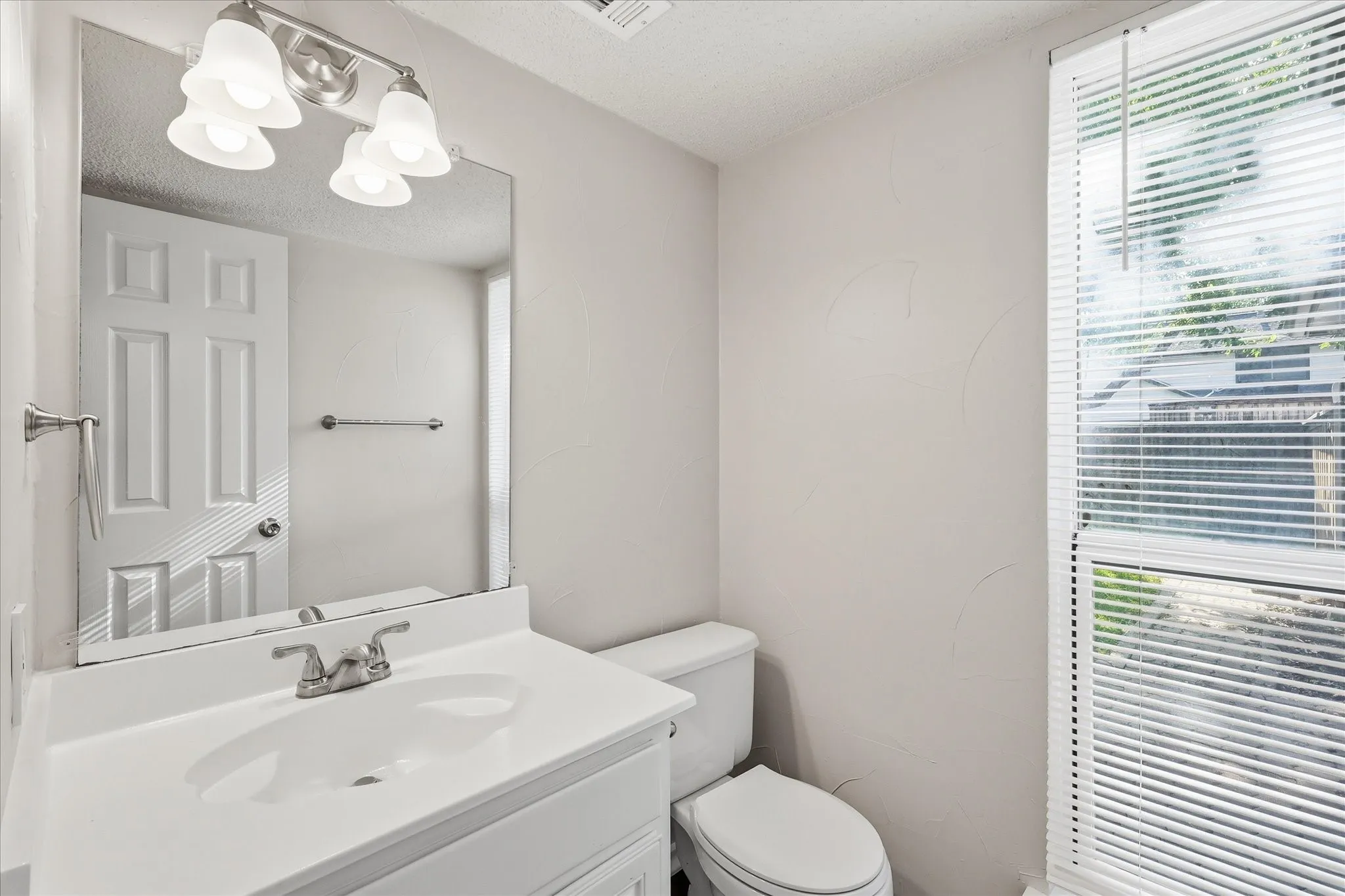 A conveniently located powder bath offers a bright vanity area and natural light for guests.