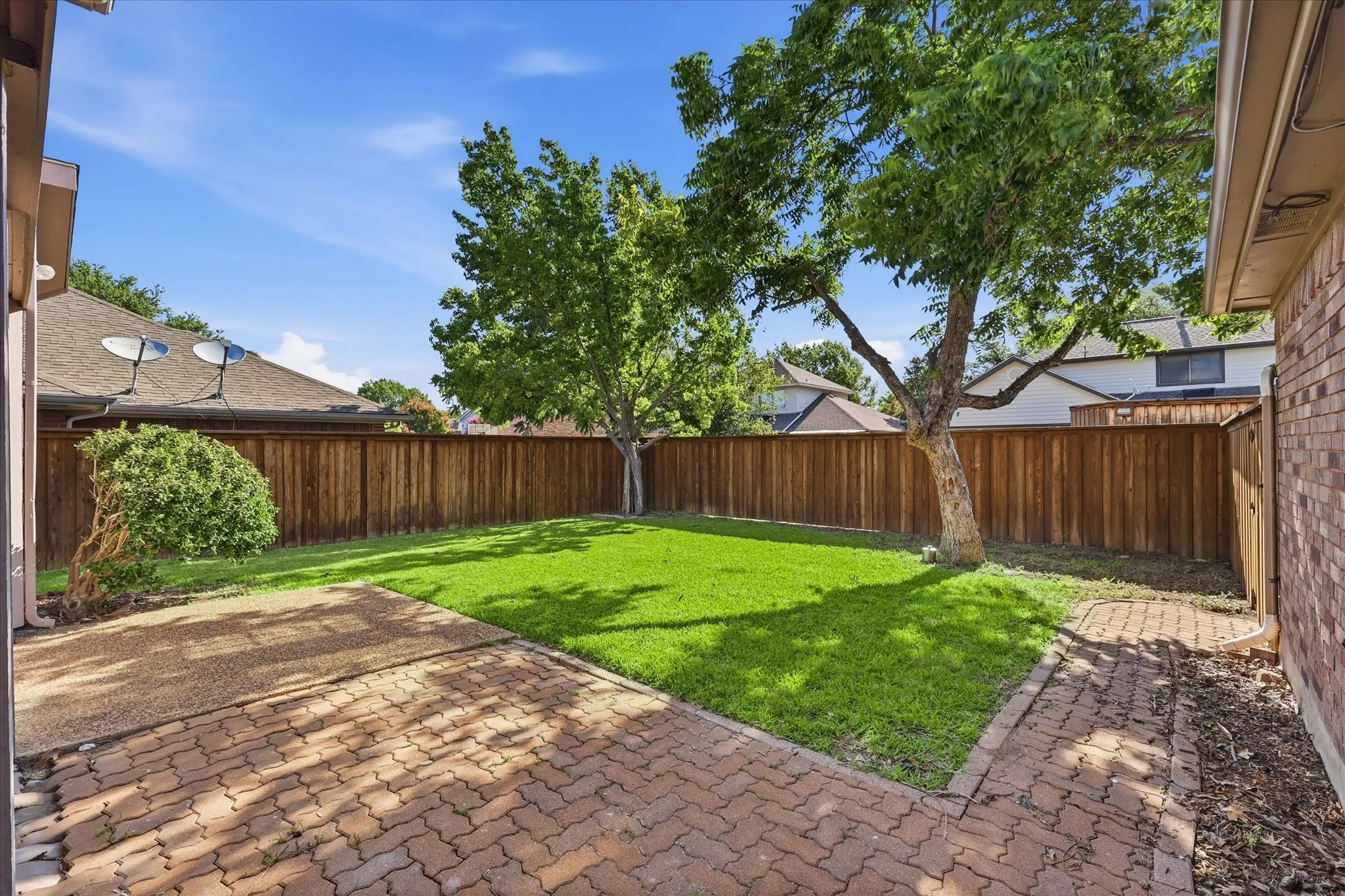 Step outside to a private, tree-shaded backyard with a paved patio and plenty of room for outdoor dining and entertaining.