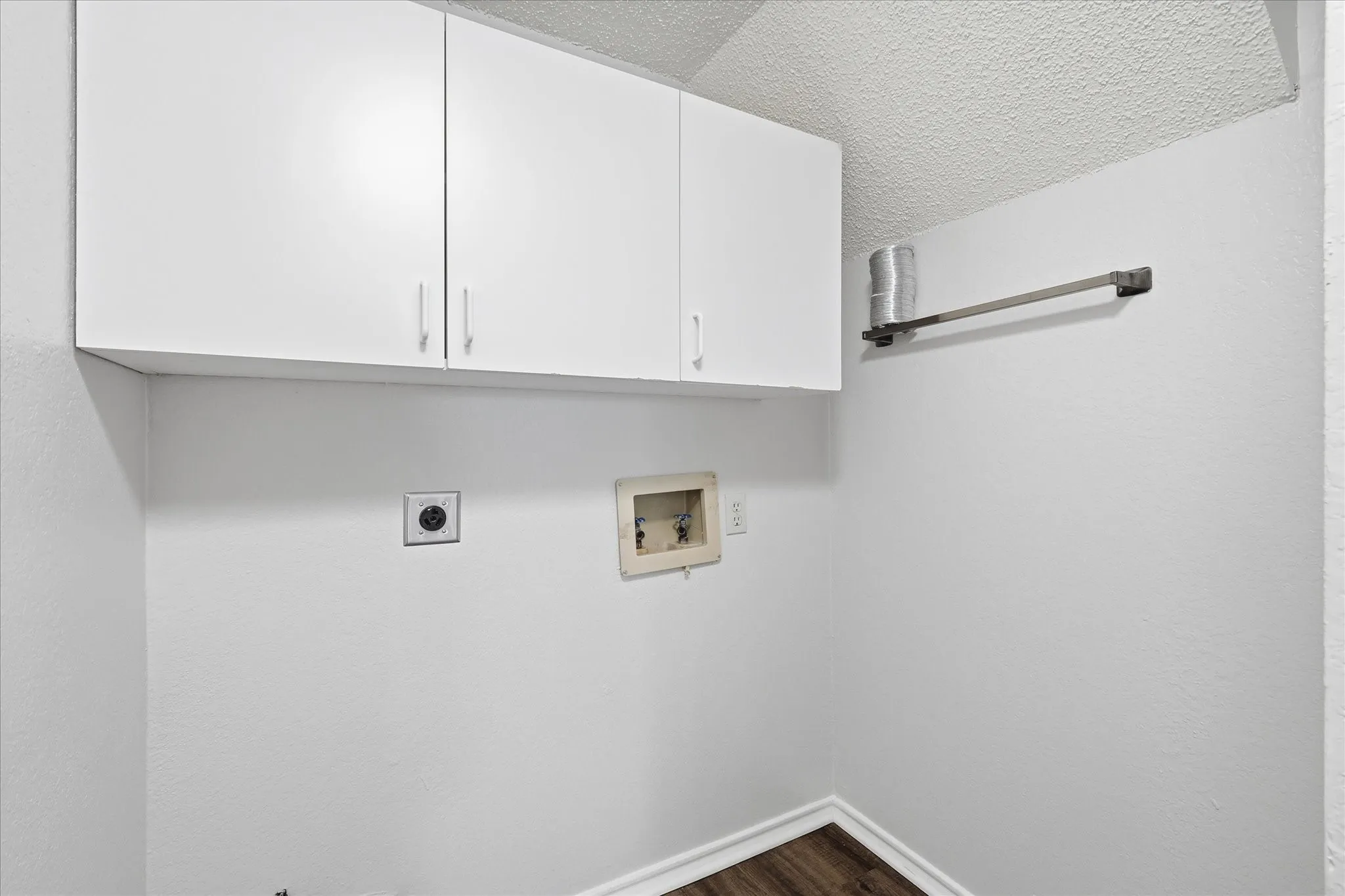 A dedicated laundry space with overhead cabinetry keeps everyday essentials neatly organized and within easy reach.