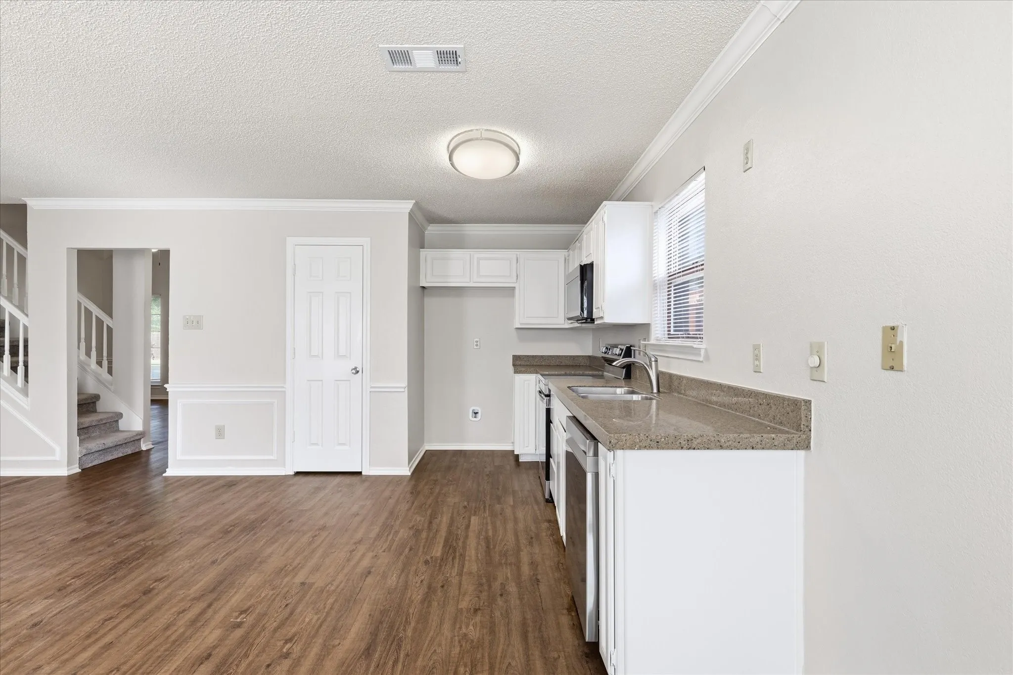Crisp white cabinetry, stainless-steel appliances and generous counter space create a clean, functional kitchen ready for your personal touch.