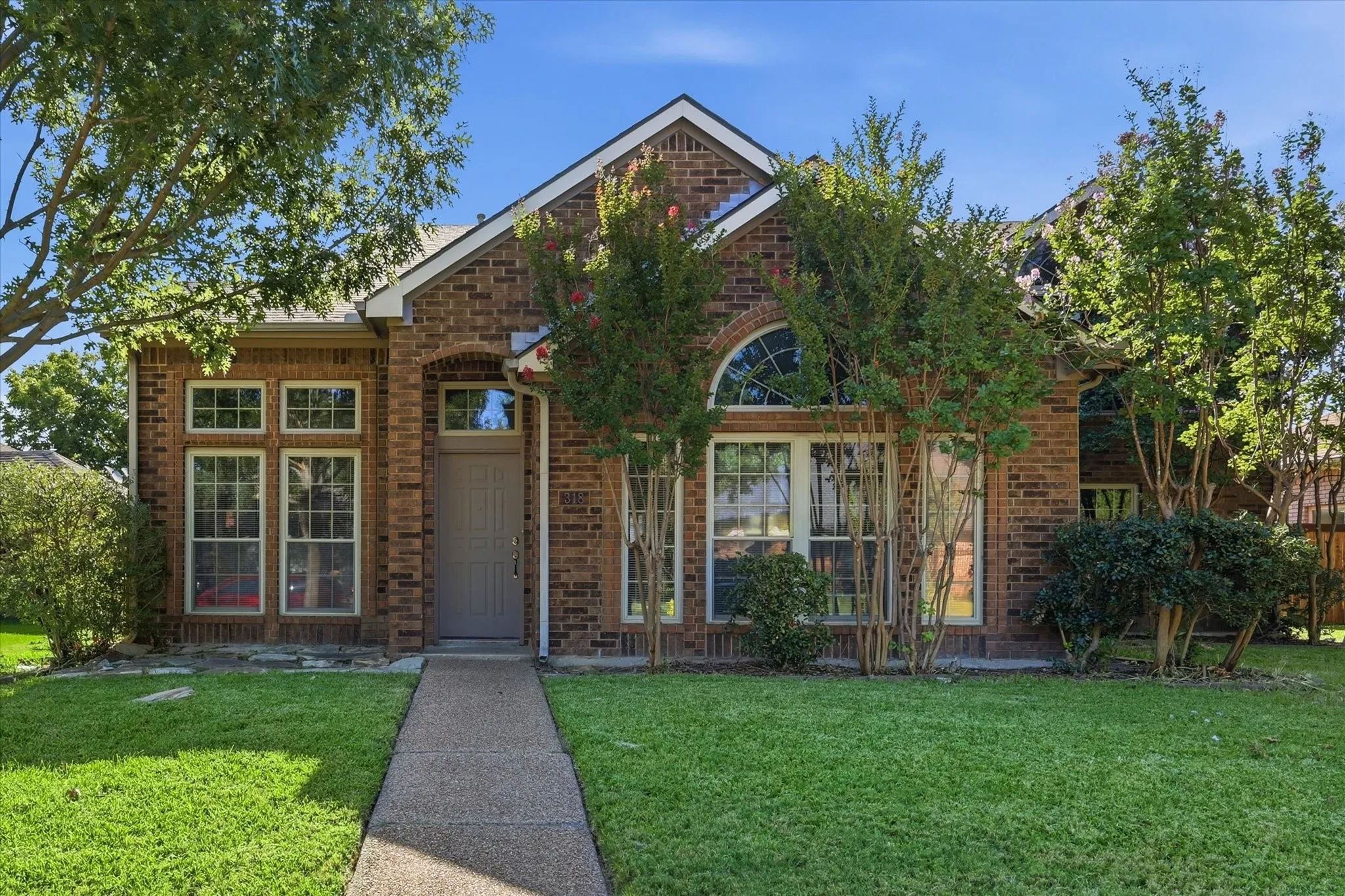 Distinctive rooflines, arched architectural details and abundant windows give this charming brick home timeless character.
