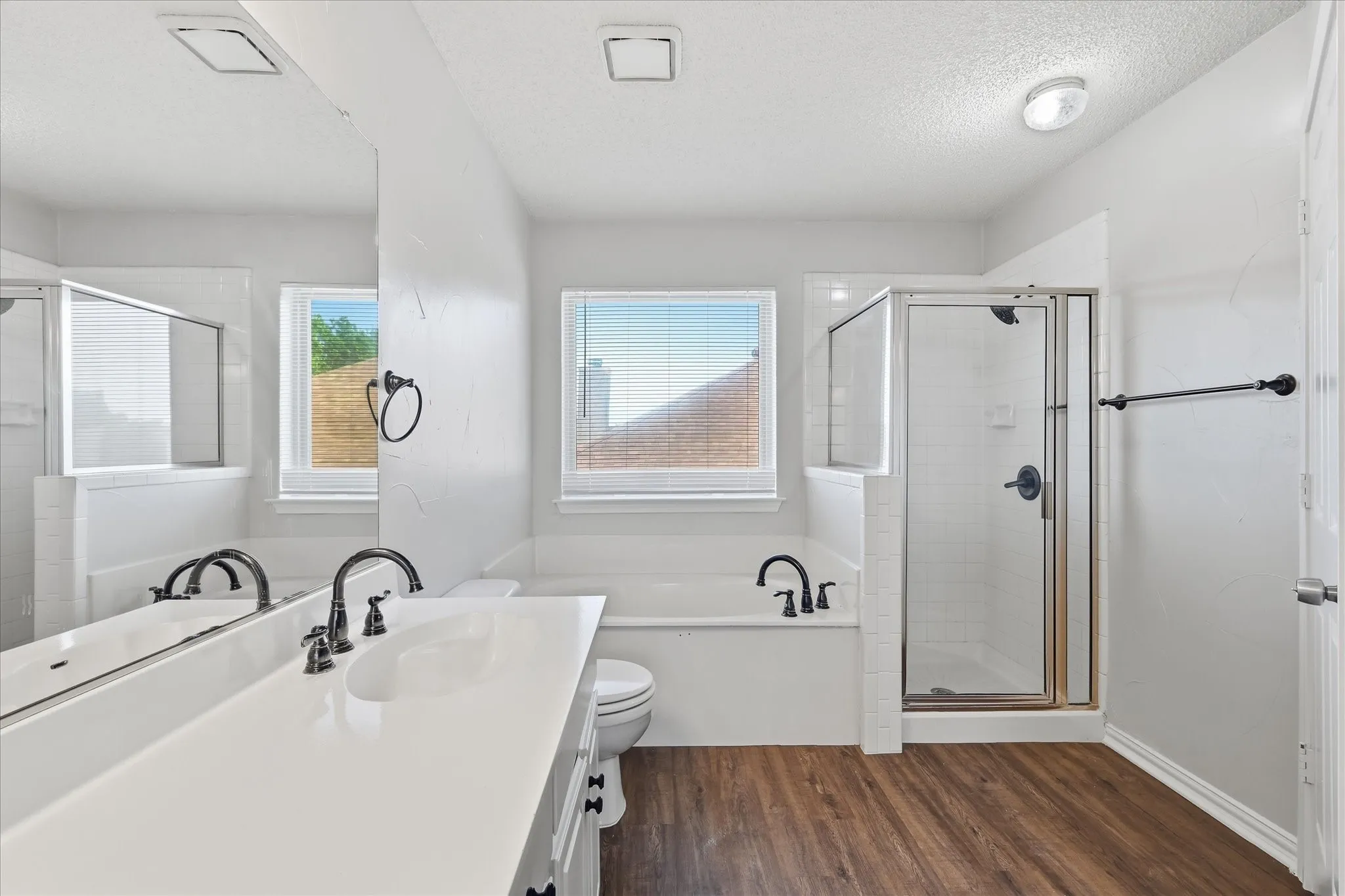 A separate glass-enclosed shower and relaxing soaking tub create a comfortable, functional primary bath layout.