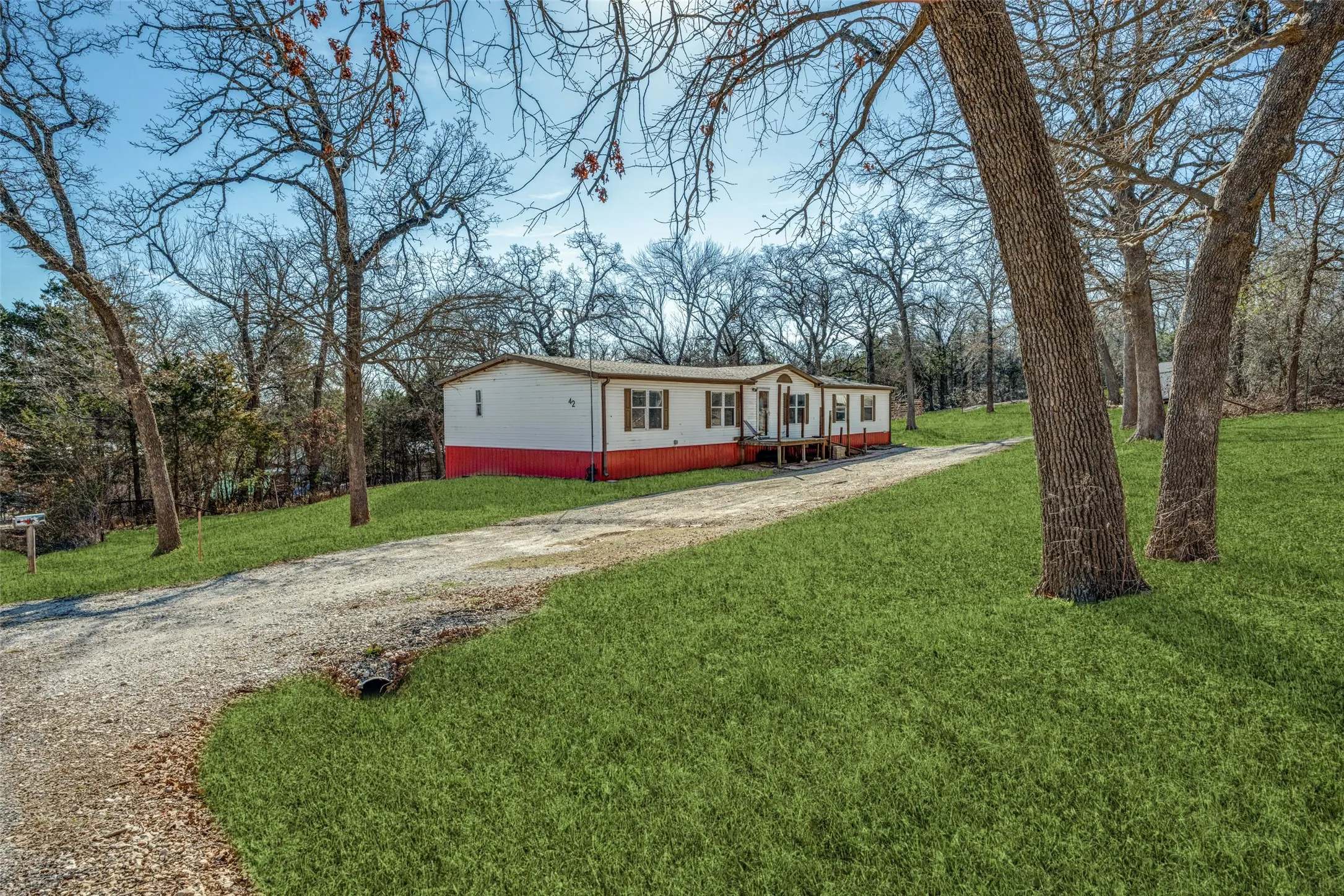 Front of home with plenty of mature trees and driveway that goes all the way through to another street.  Easy access for boats, trailers, or motorhomes.