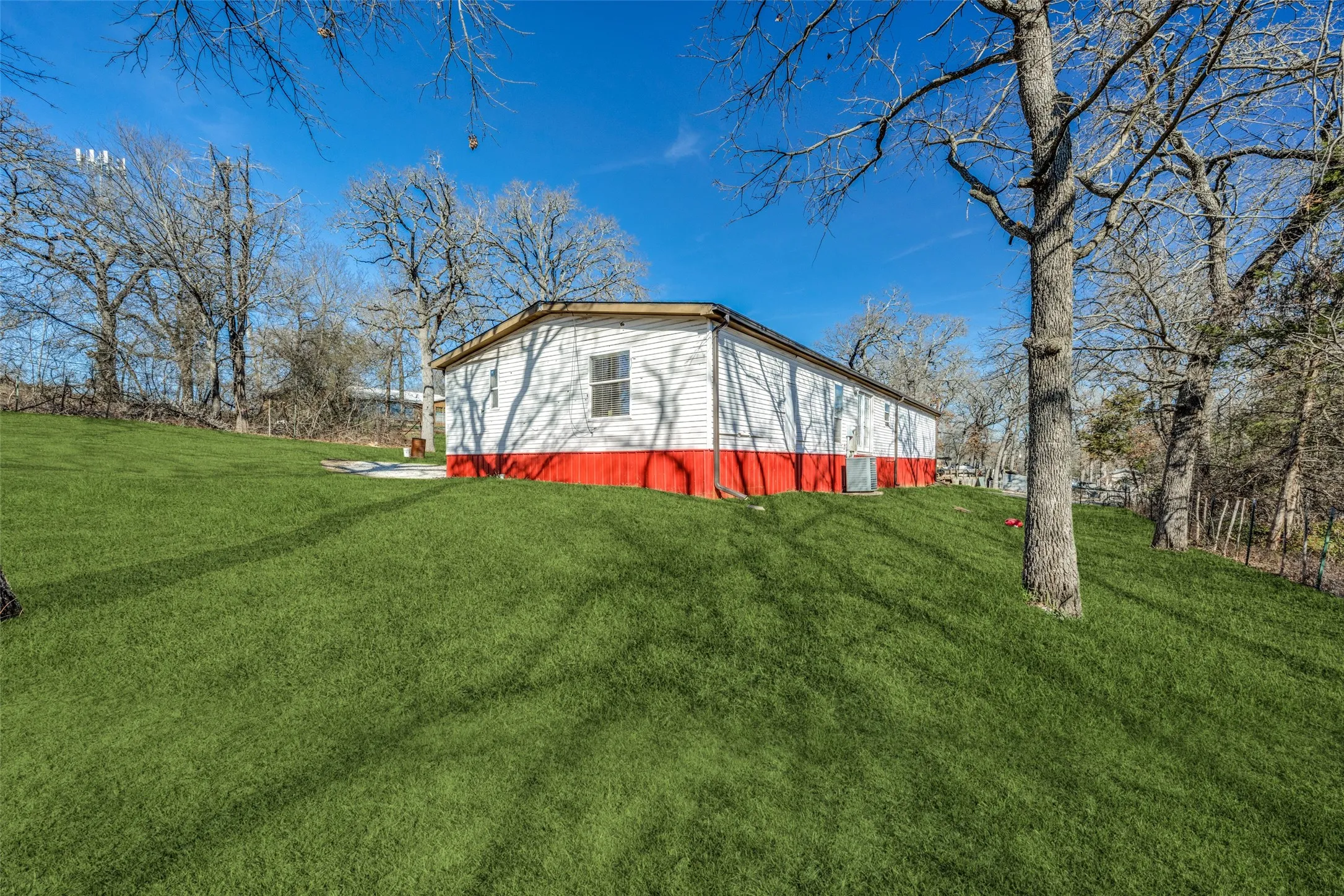 Other side of home showing the large back yard.  Virtually staged grass.
