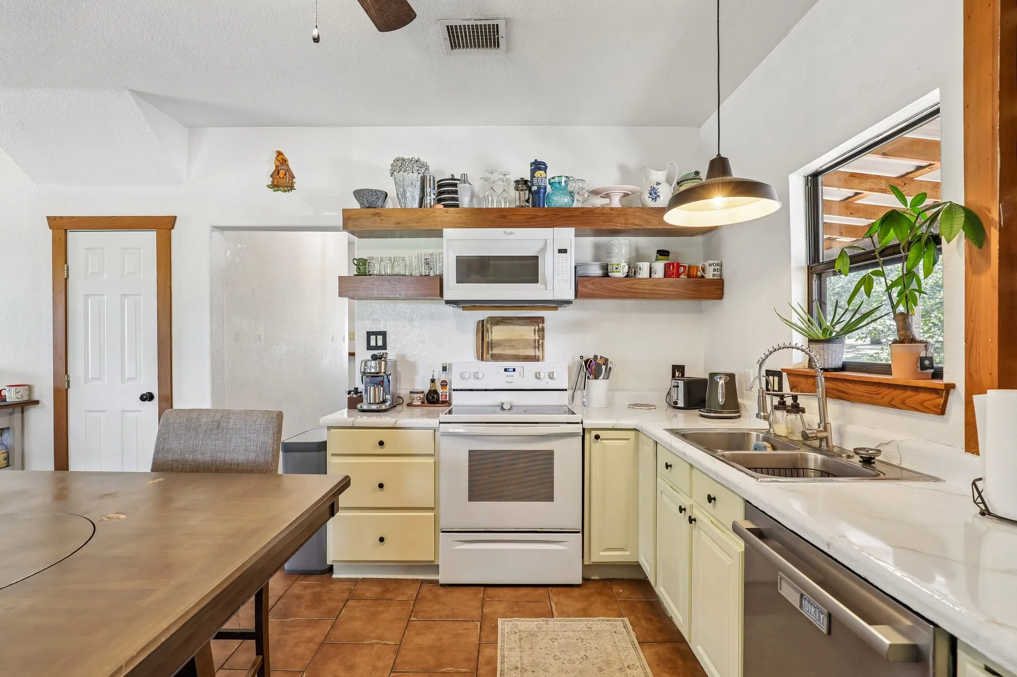 Kitchen featuring white countertops, light-colored cabinetry, and terracotta-style flooring