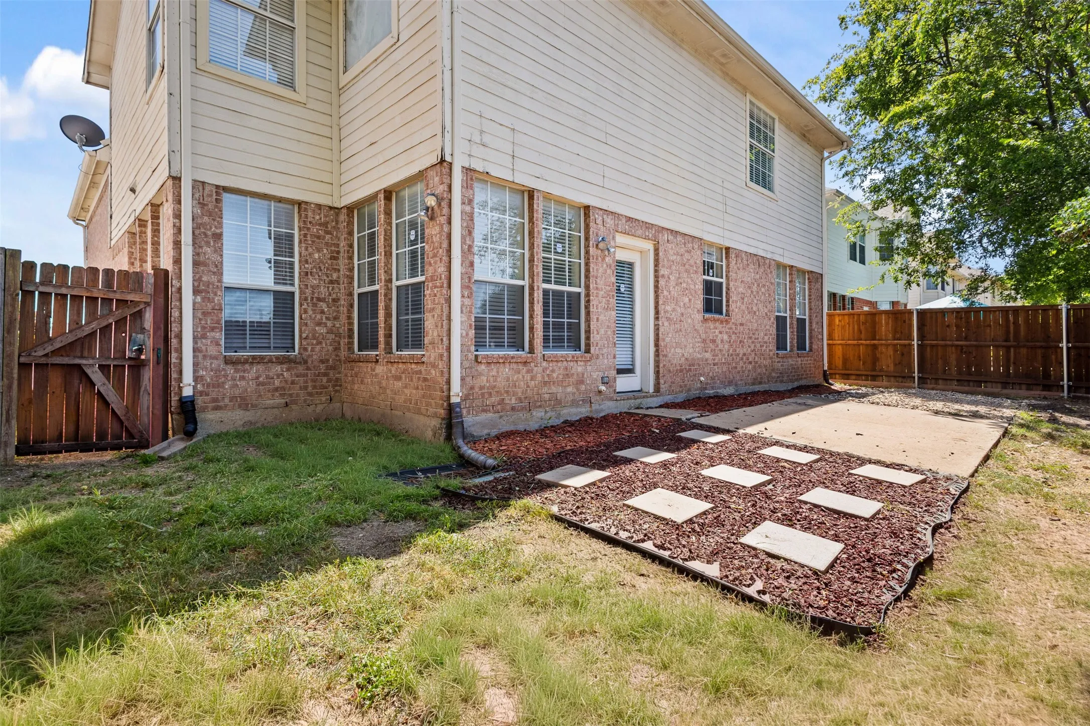 Brick and siding exterior featuring multiple windows with blinds
