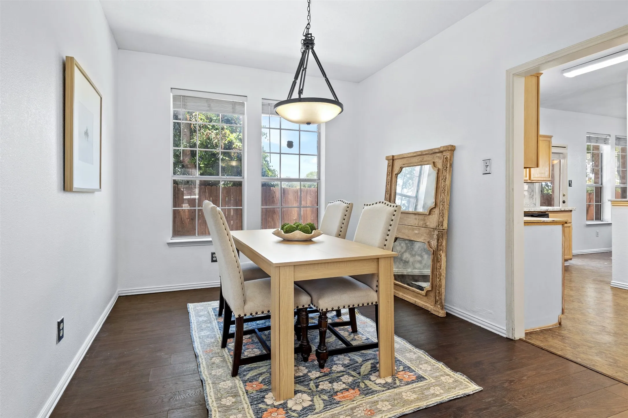 Dining area featuring wood-finish flooring, white baseboards, and two windows