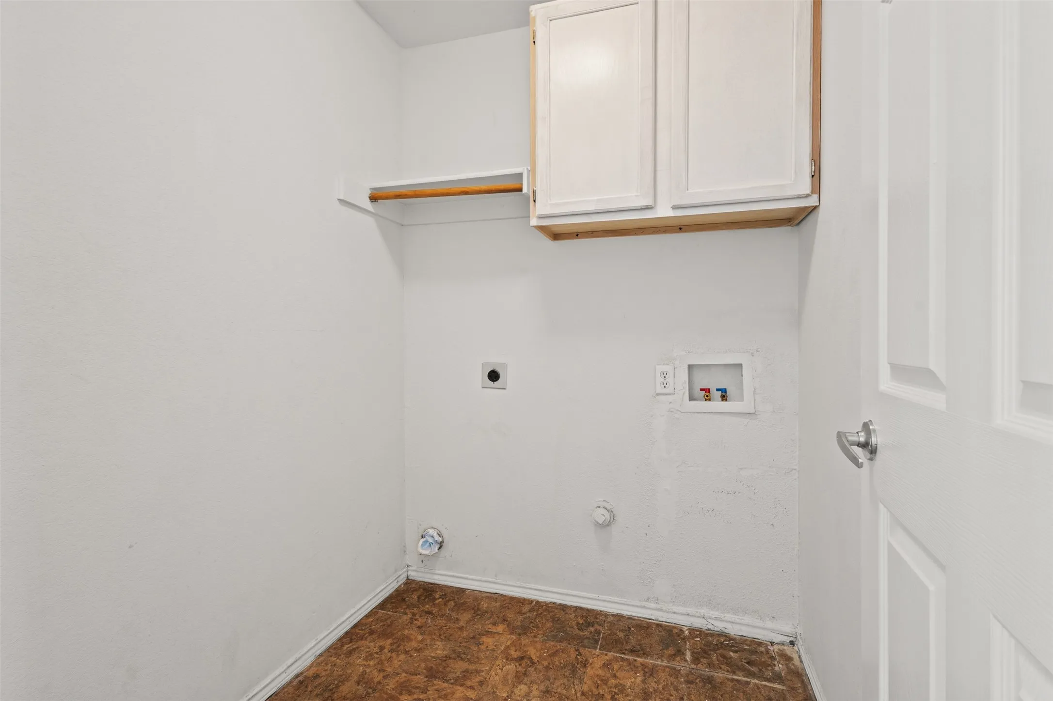 Dedicated utility space featuring overhead cabinetry and a built-in hanging rod