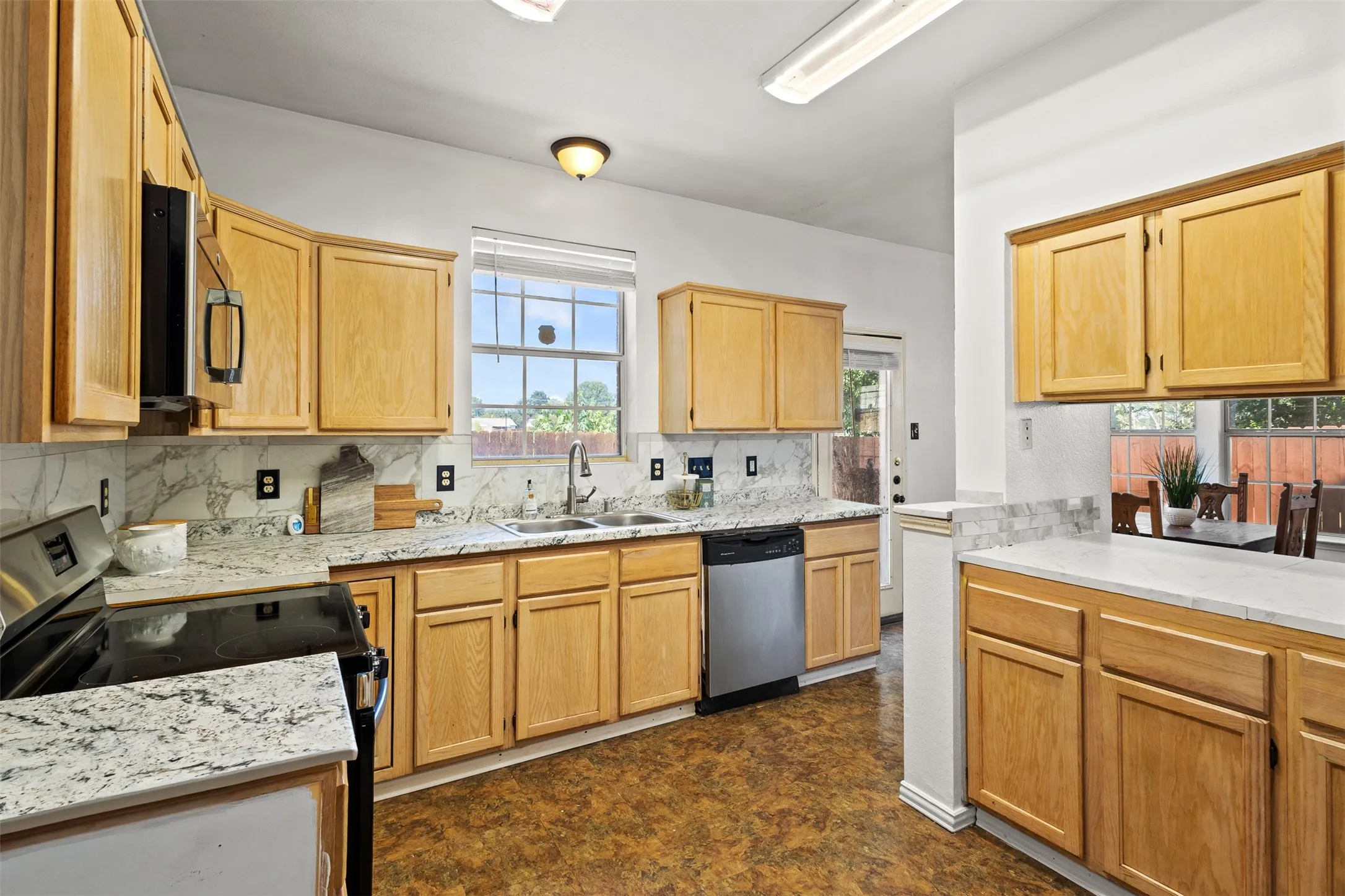 Kitchen featuring wood cabinetry, stainless steel appliances, and a double basin sink