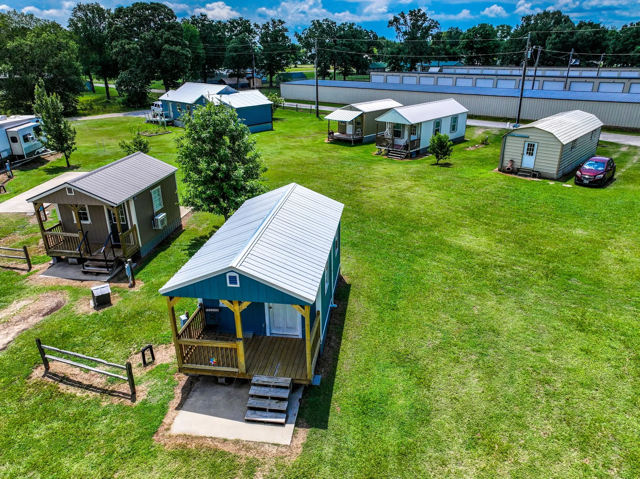 Collection of compact structures featuring individual front porches, metal roofs, and exterior siding