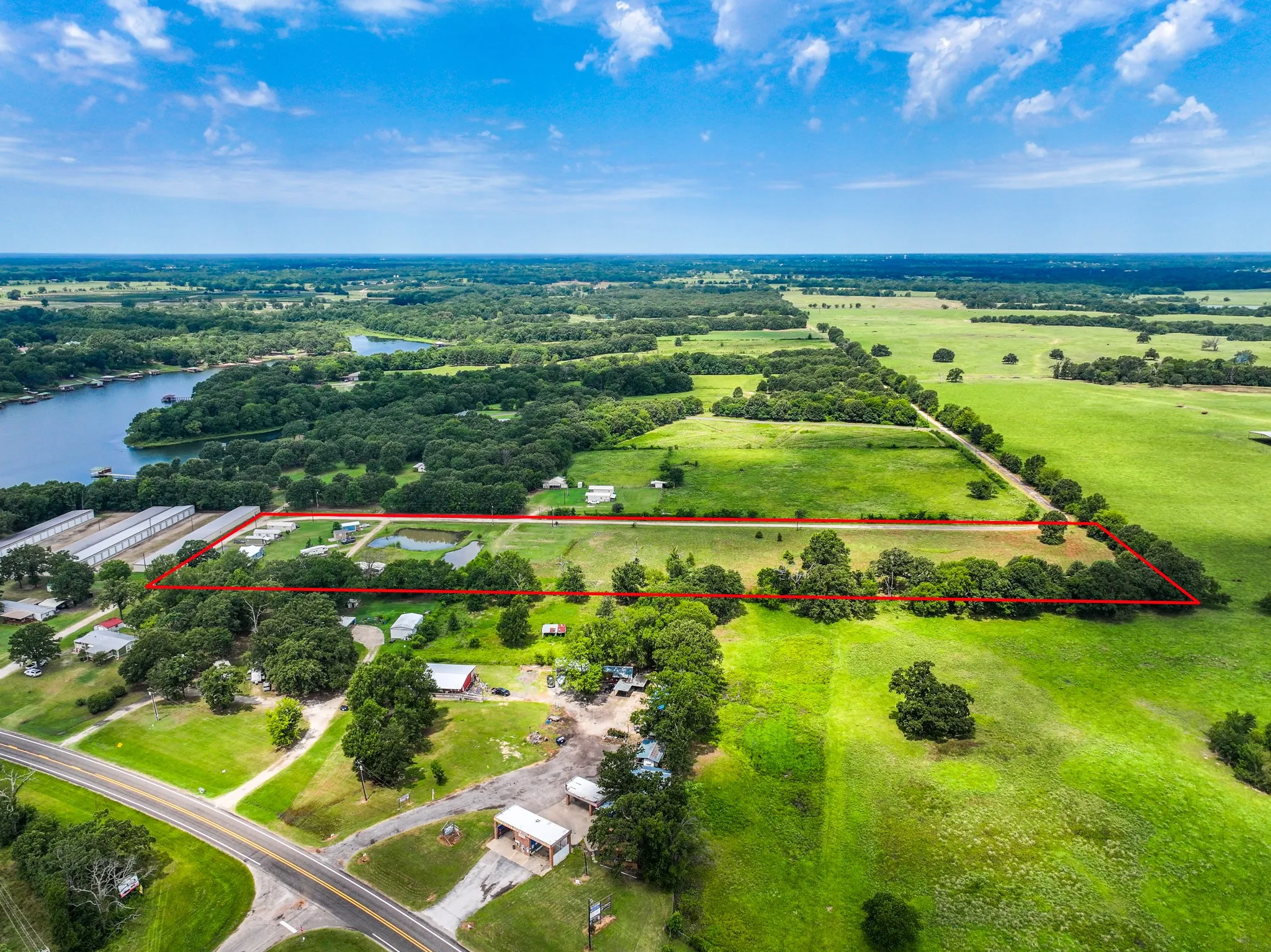 Expansive acreage featuring a private pond, mature trees, open pastures, and access to a public road