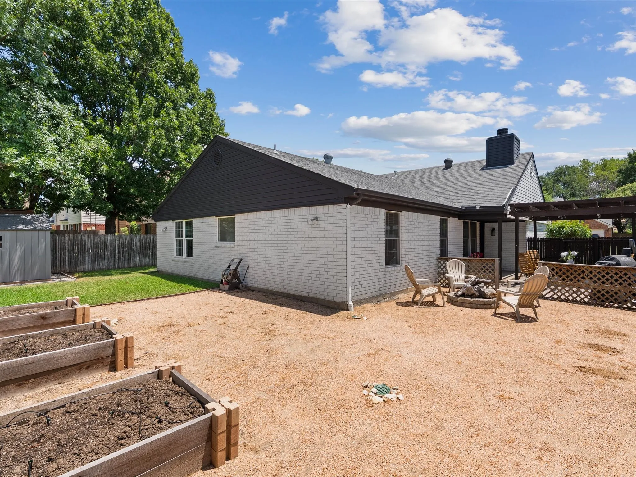 Backyard with garden area, fire pit, and storage shed