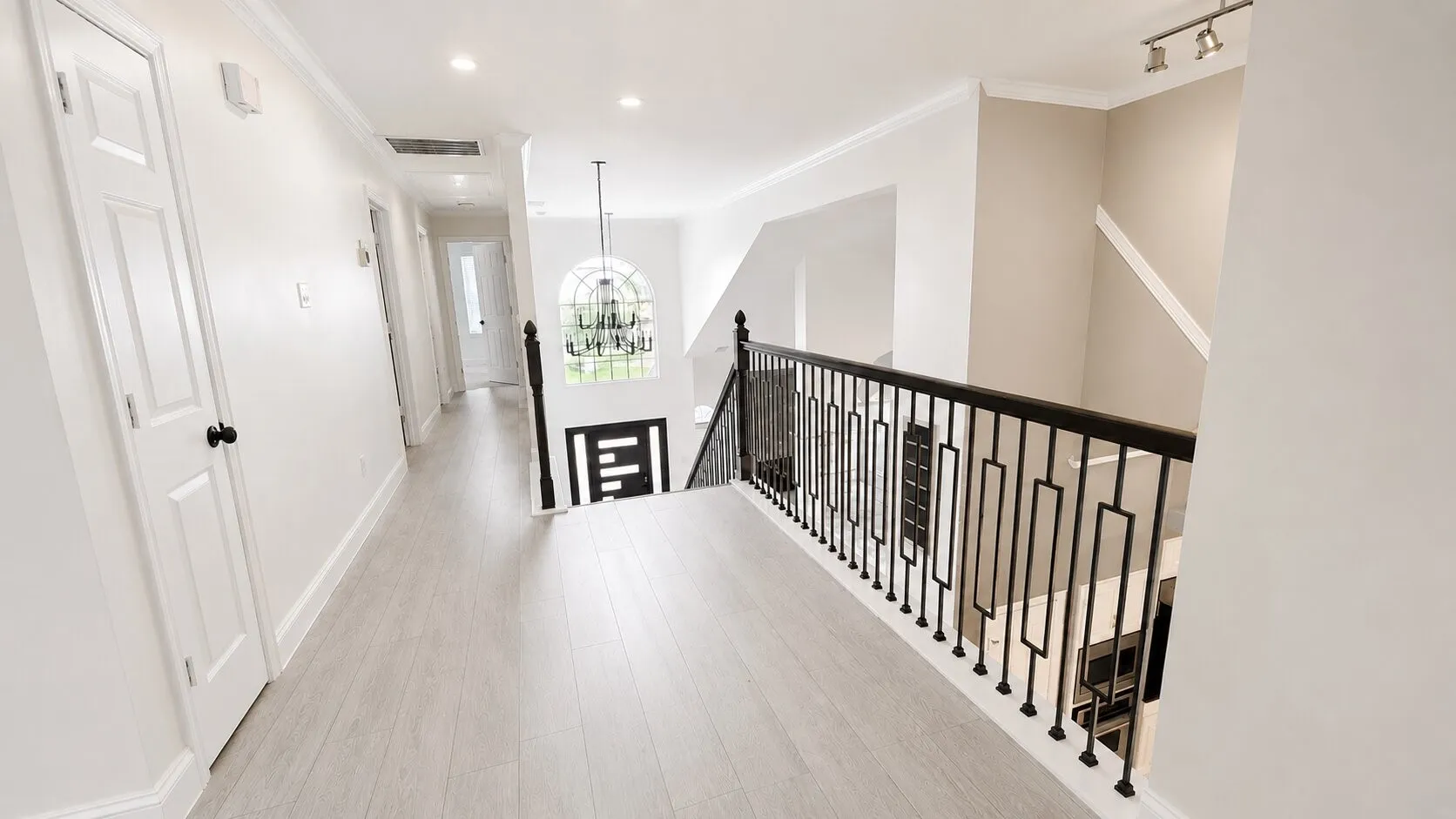 Upper-level hallway featuring light wood-finish flooring, recessed lighting, and white trim