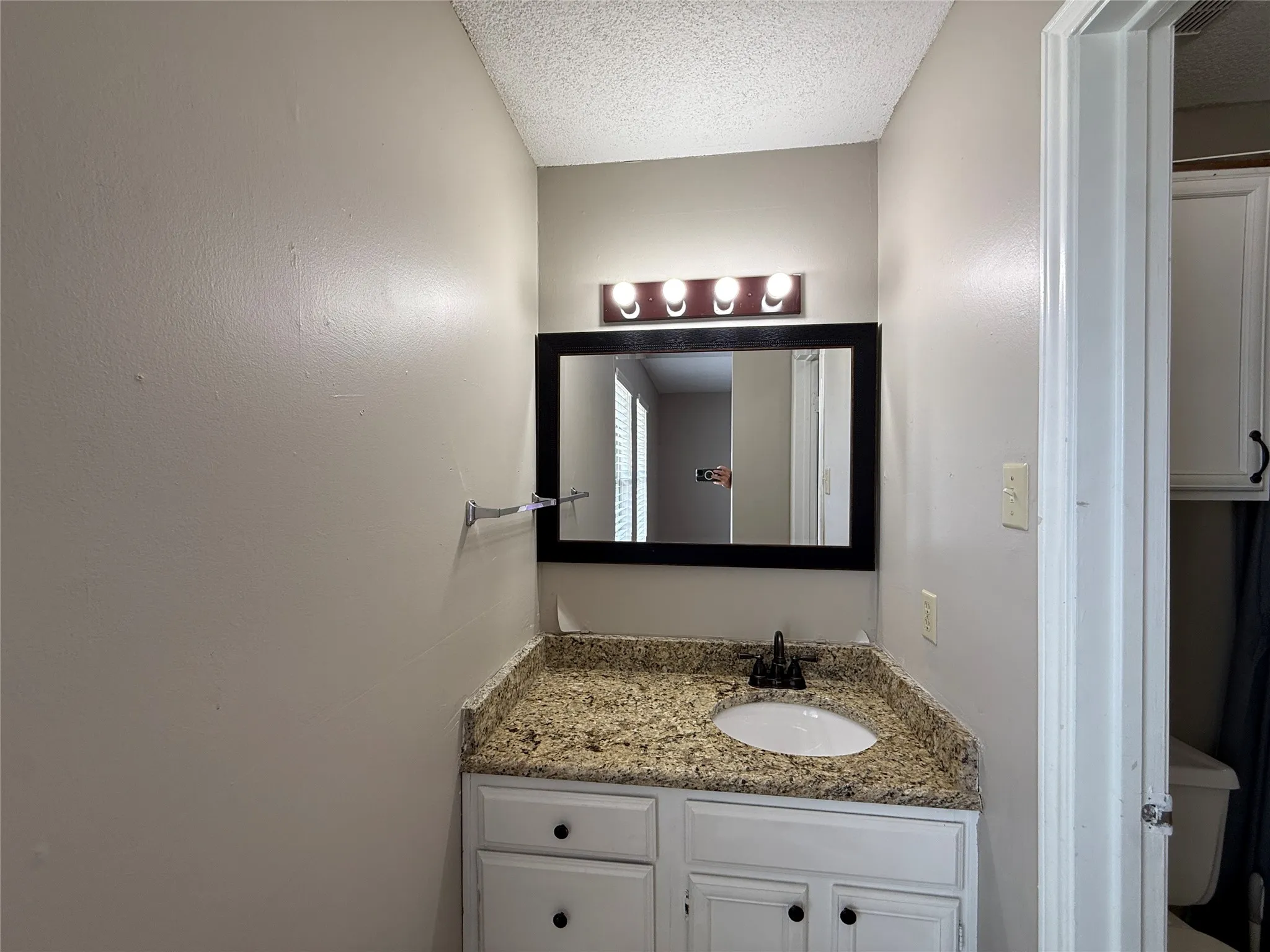 Bathroom featuring vanity and a textured ceiling