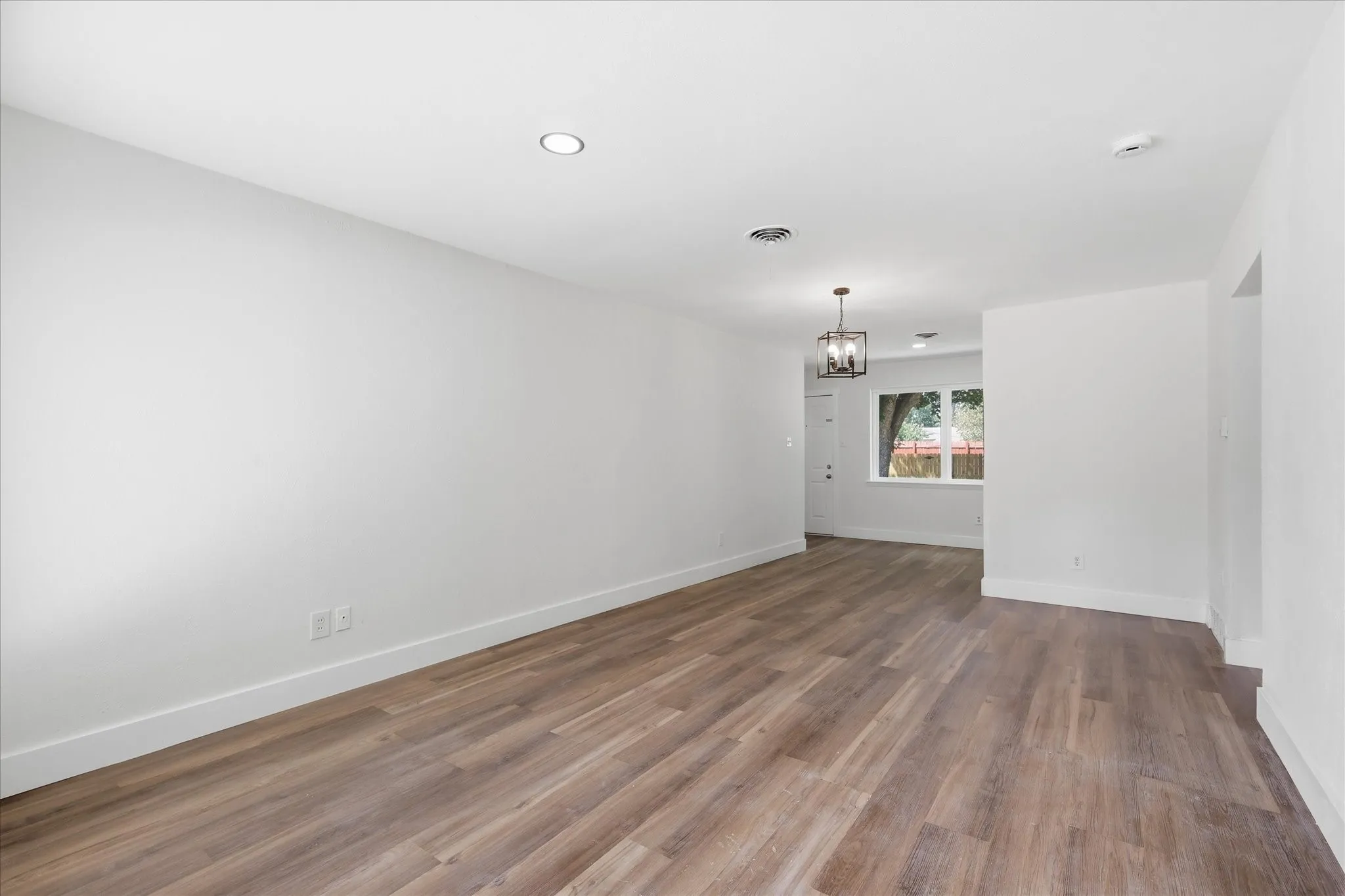Spacious interior featuring wood-finish flooring, white walls, and recessed lighting
