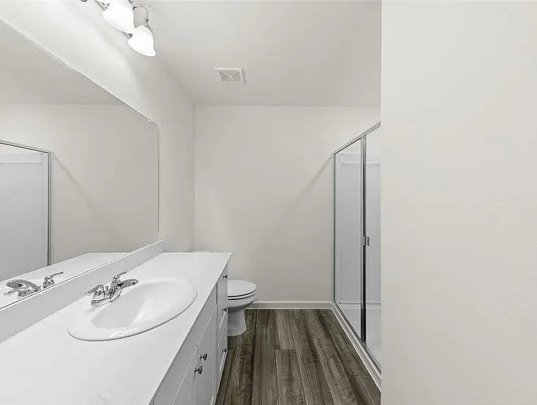 Bathroom featuring a white vanity with an integrated sink and chrome faucet