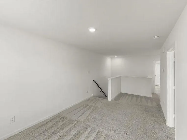 Open loft area featuring neutral-toned carpeting, recessed lighting, and white​​‌​​​​‌​​‌‌​‌‌​​​‌‌​‌​‌​‌​​​‌​​ walls