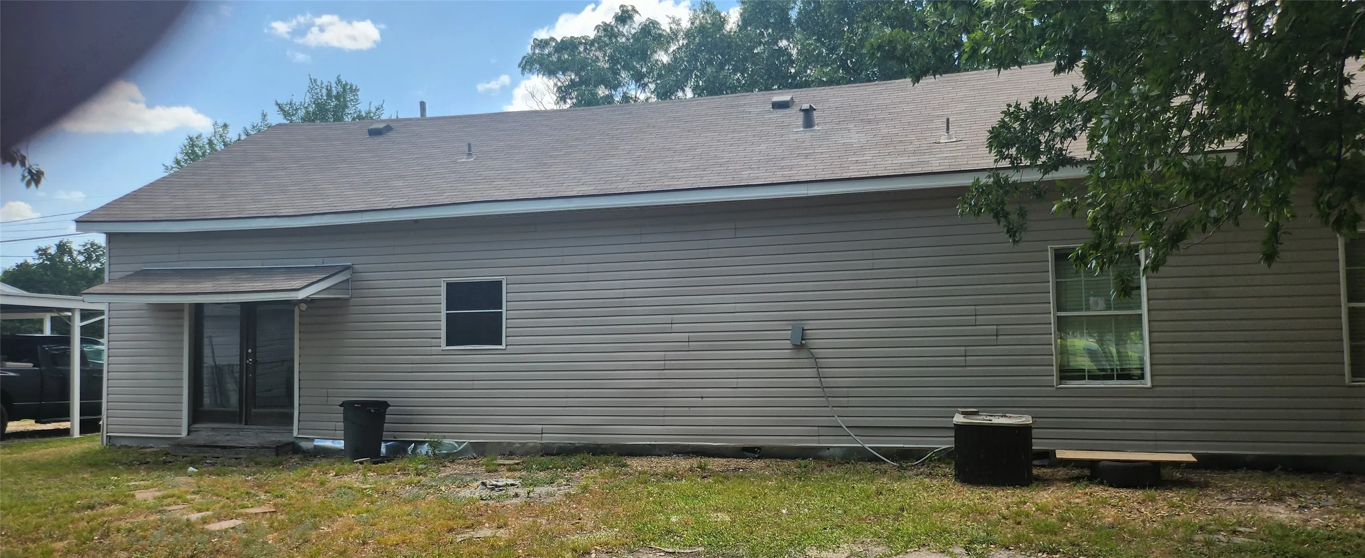 Exterior siding in a neutral tone with a brown shingle roof