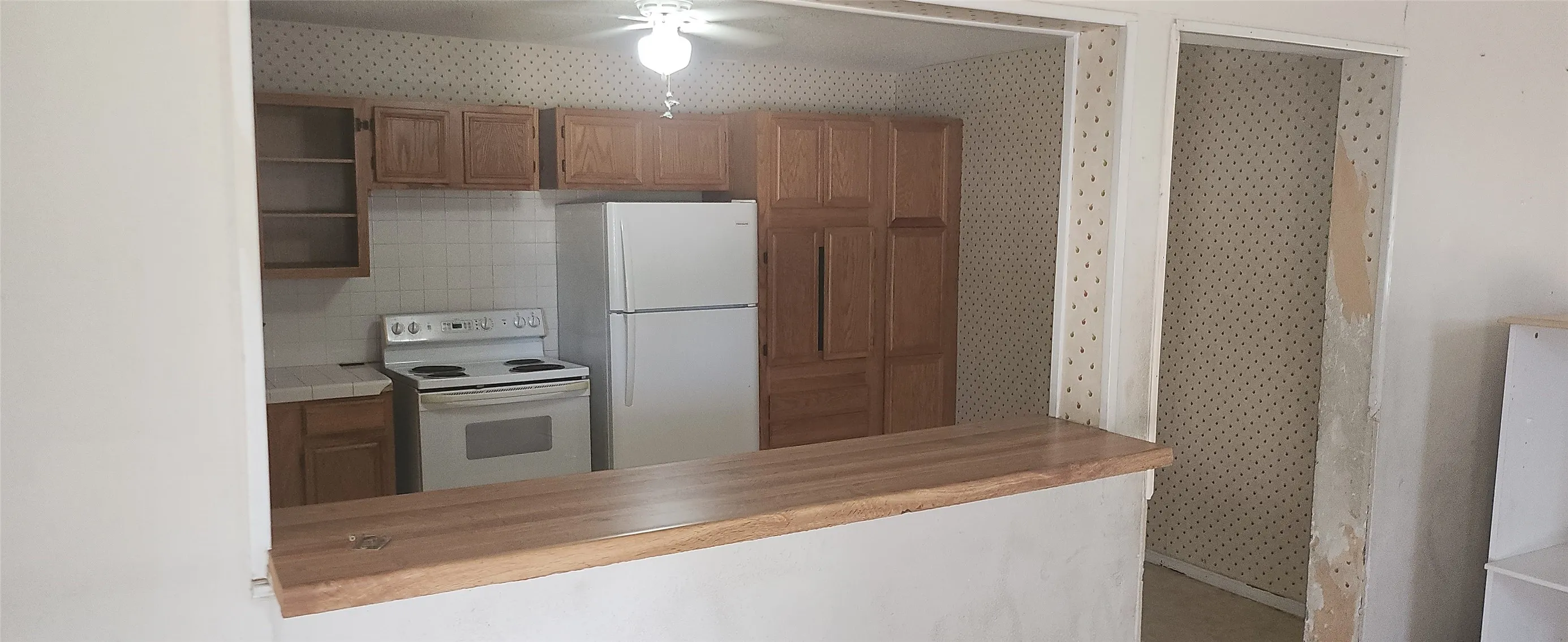 Kitchen pass-through featuring a wood-finish countertop