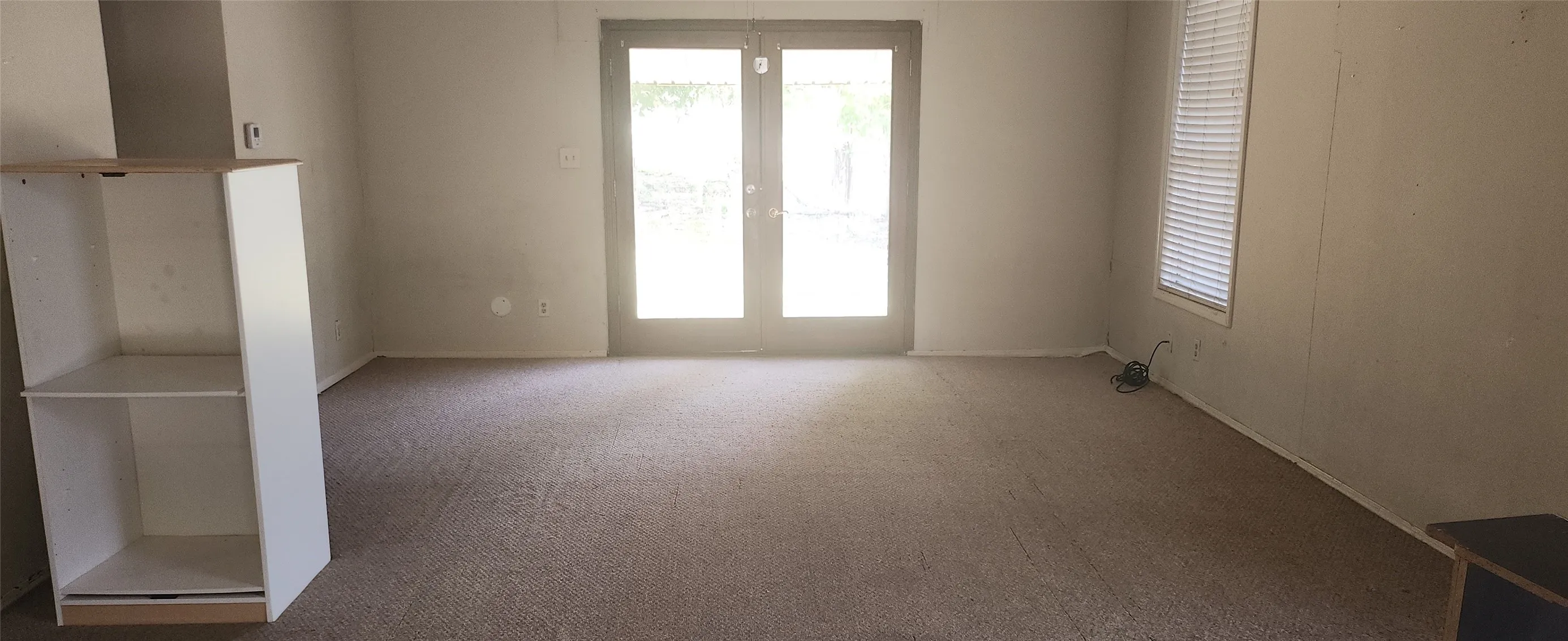 Spacious room featuring neutral carpet flooring and light-toned walls