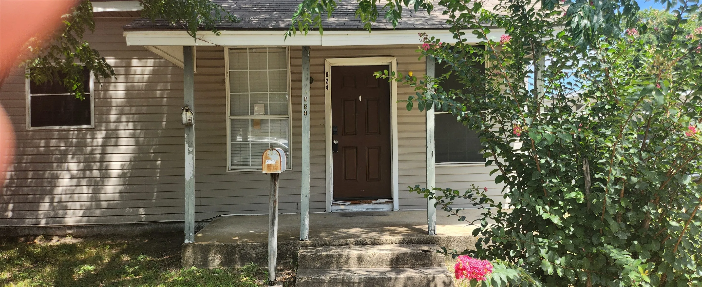Front exterior featuring horizontal siding, a covered porch, a paneled entry door, and concrete steps