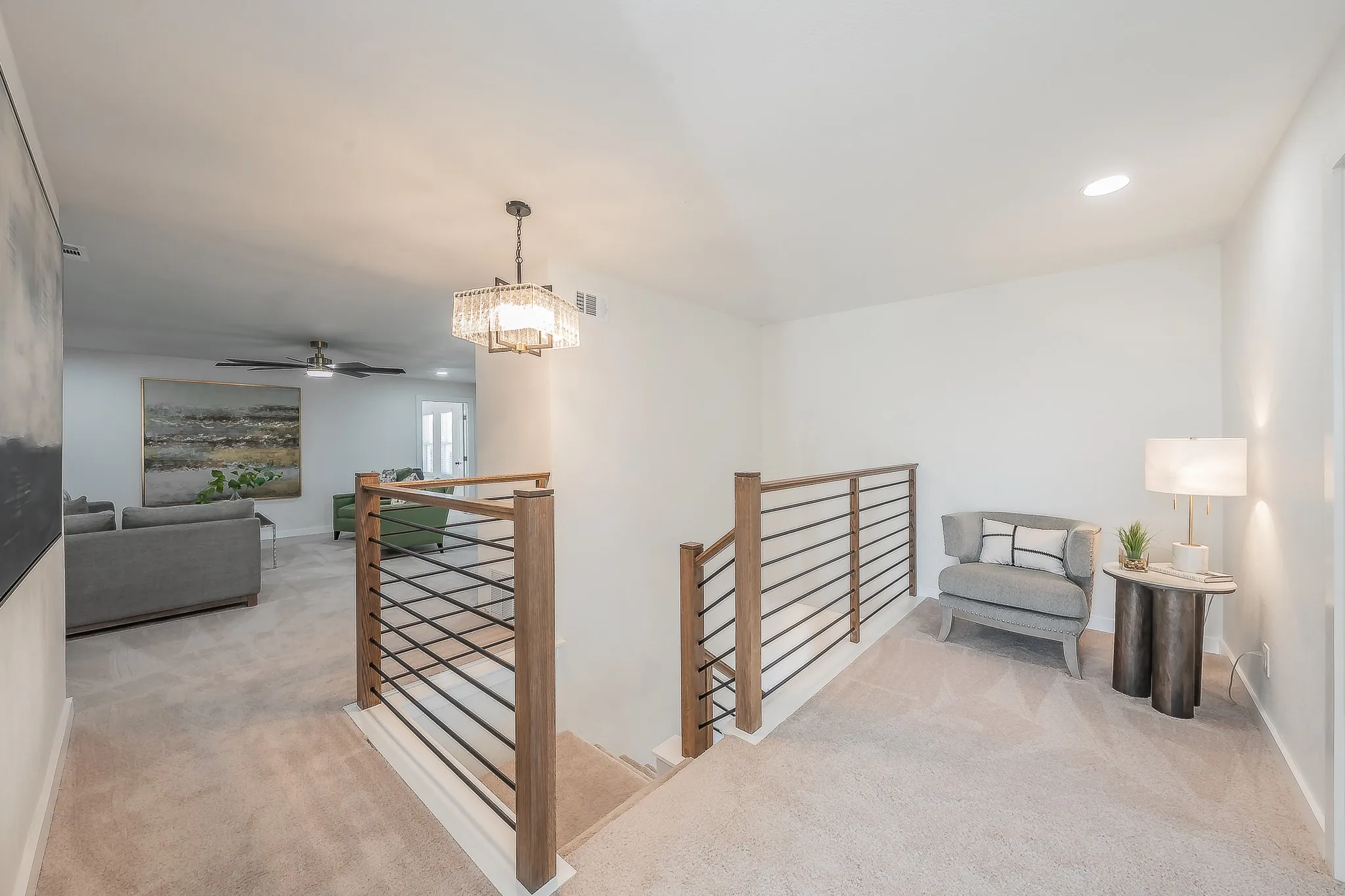 Open-concept upper level featuring a contemporary railing system with wood-finish newel posts and black horizontal balusters