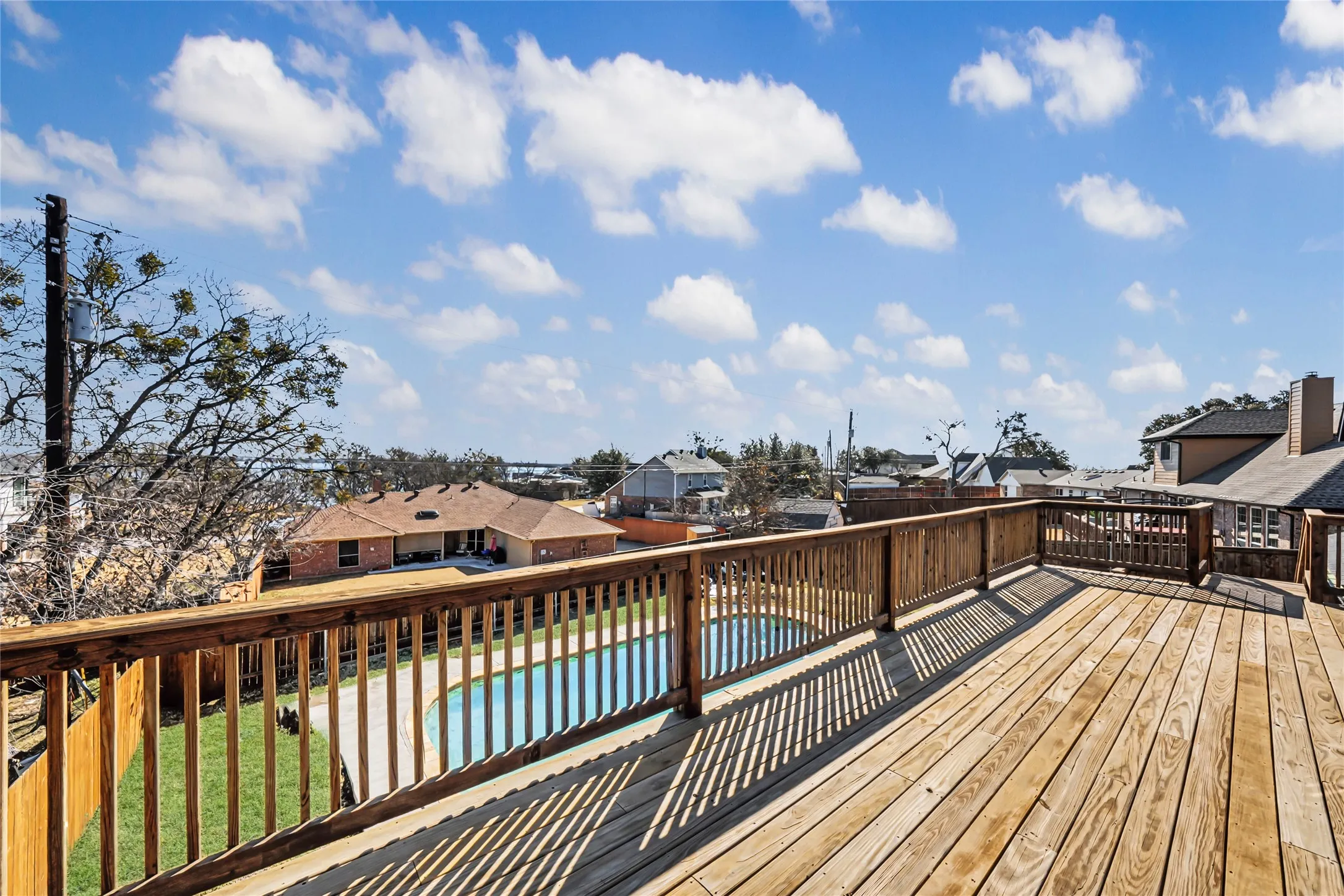 Expansive wooden deck featuring horizontal plank flooring and a slatted railing