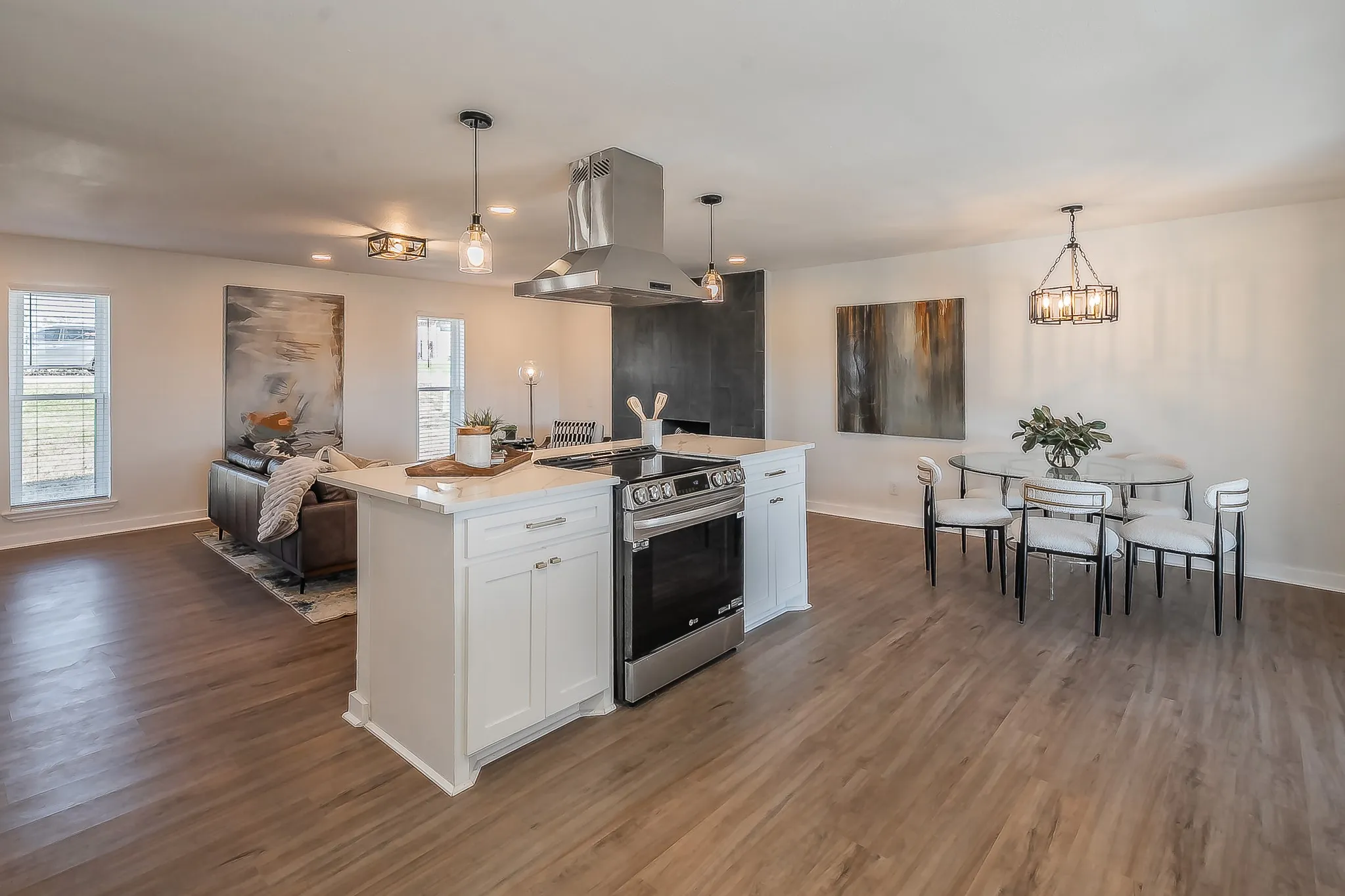 Open concept living area featuring wood-finish flooring, white walls, and recessed lighting